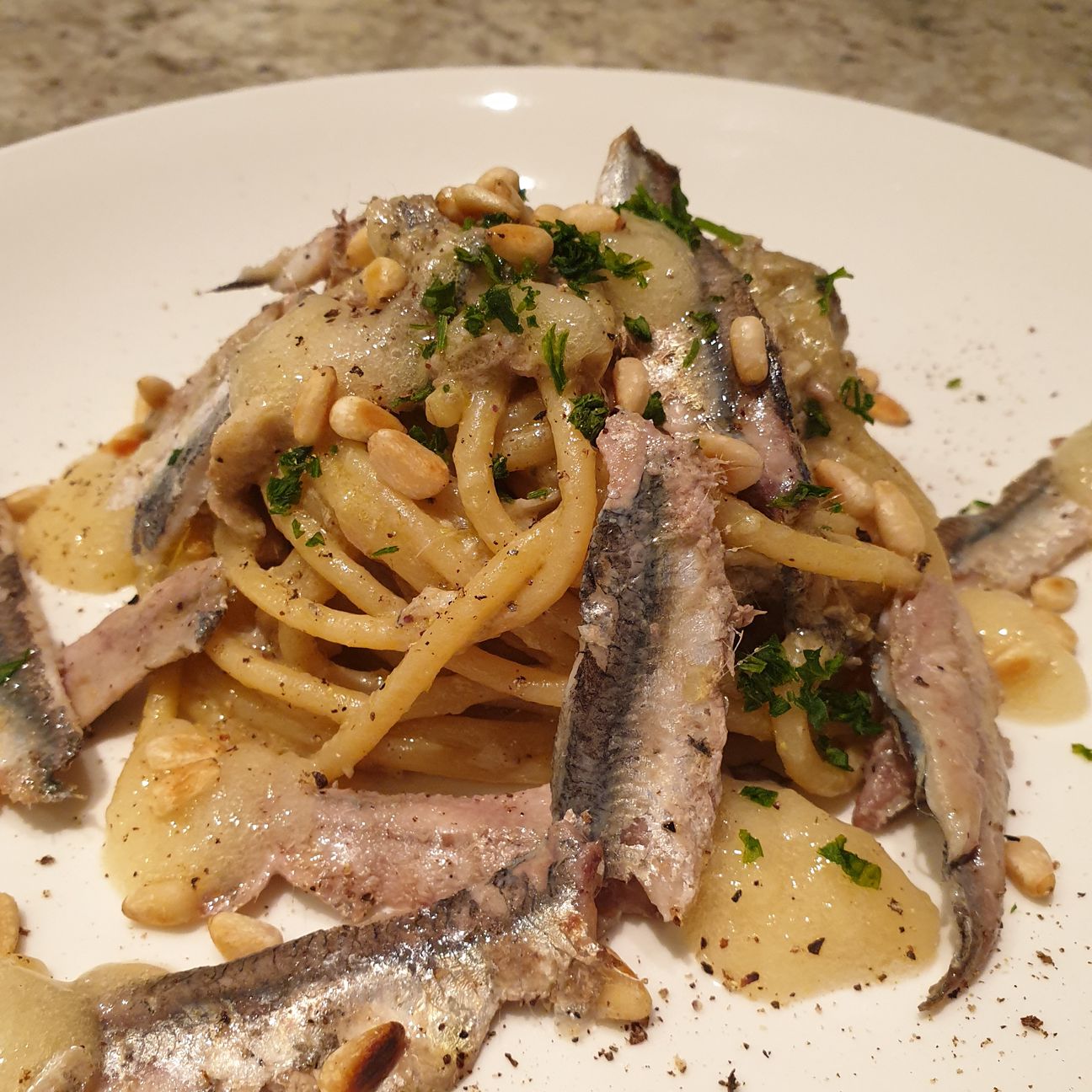 Spaghettoni con alici fresche, crema di pistacchio, colatura d'alici, gel di bergamotto e pinoli