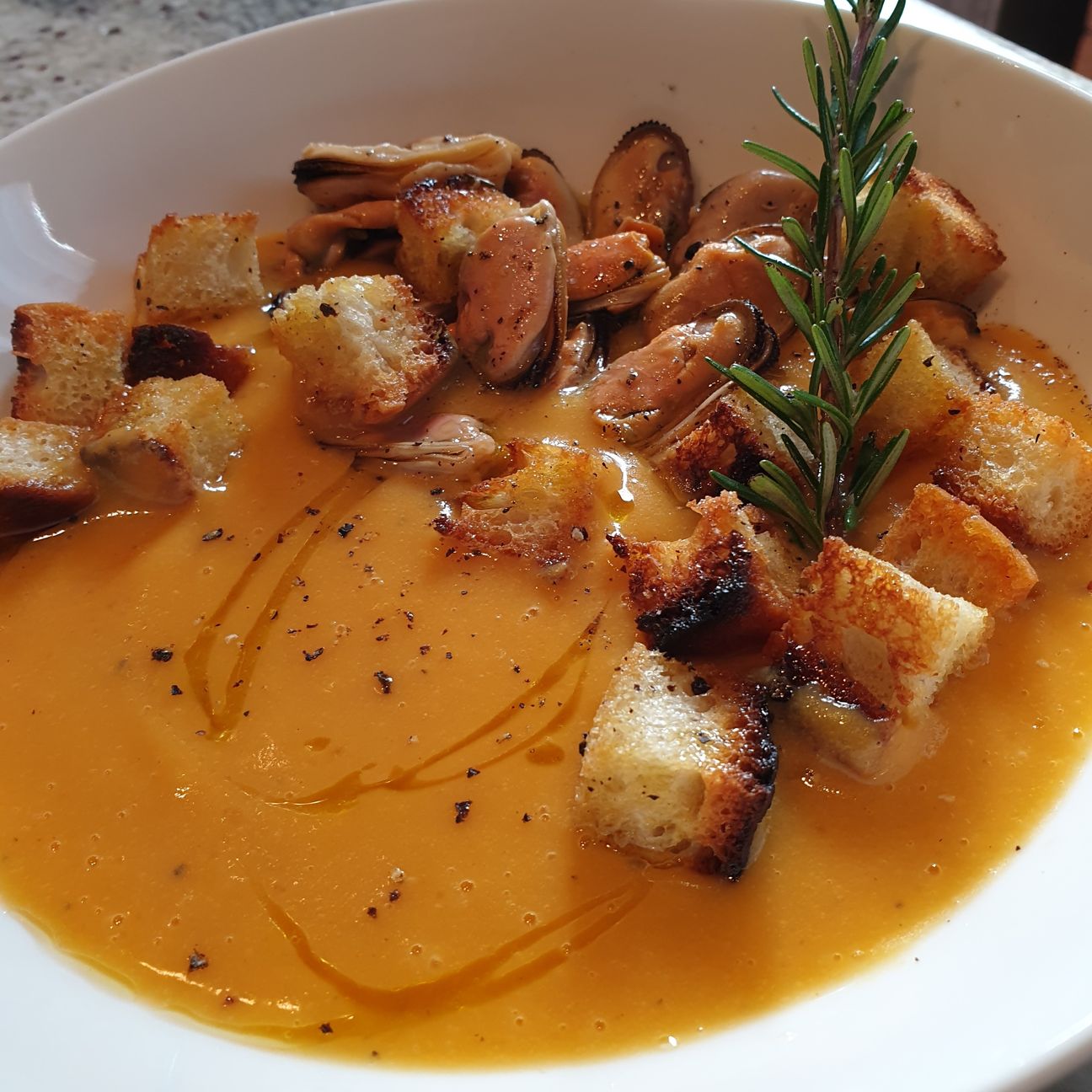 Vellutata di zucca con insalata di cozze e crostini di pane