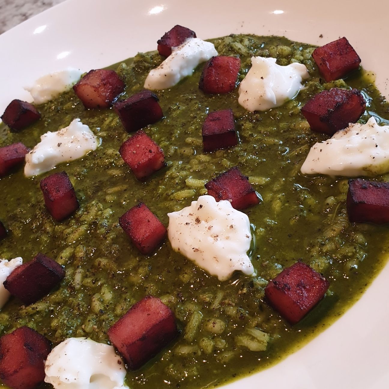 Minestra di riso con crema di cavolo nero, cubotti di mortadella piastrati e fiocchi di stracchino