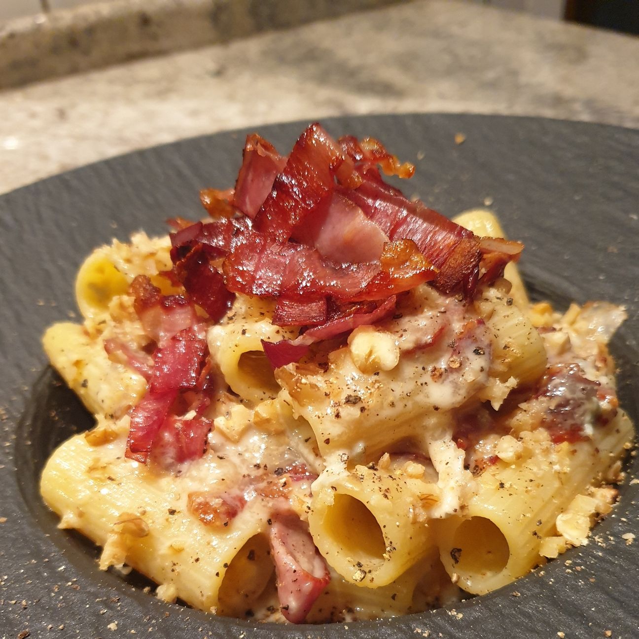 Rigatoni in crema di gorgonzola dolce con speck croccante e granella di noci