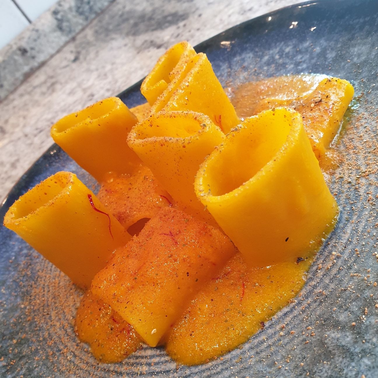 Paccheri in crema di aglione e zafferano, bottarga di tonno e polvere di alloro