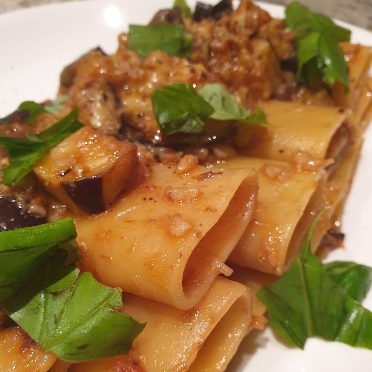 Paccheri in salsa di pomodorini e baccalà con melanzane fritte, olive taggiasche e basilico