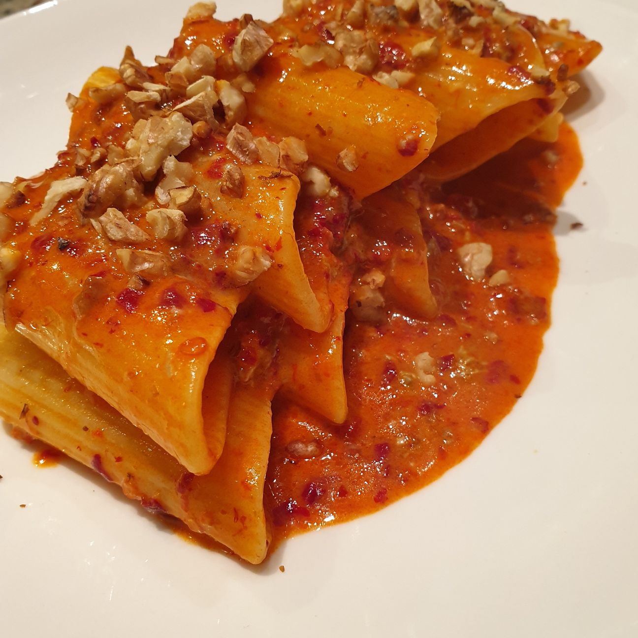 Pennoni artigianali in crema di gorgonzola e 'nduja, salsa Sriracha e noci tostate