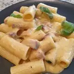 Ricetta Rigatoni con crema di gorgonzola duetto, pancetta tesa e basilico