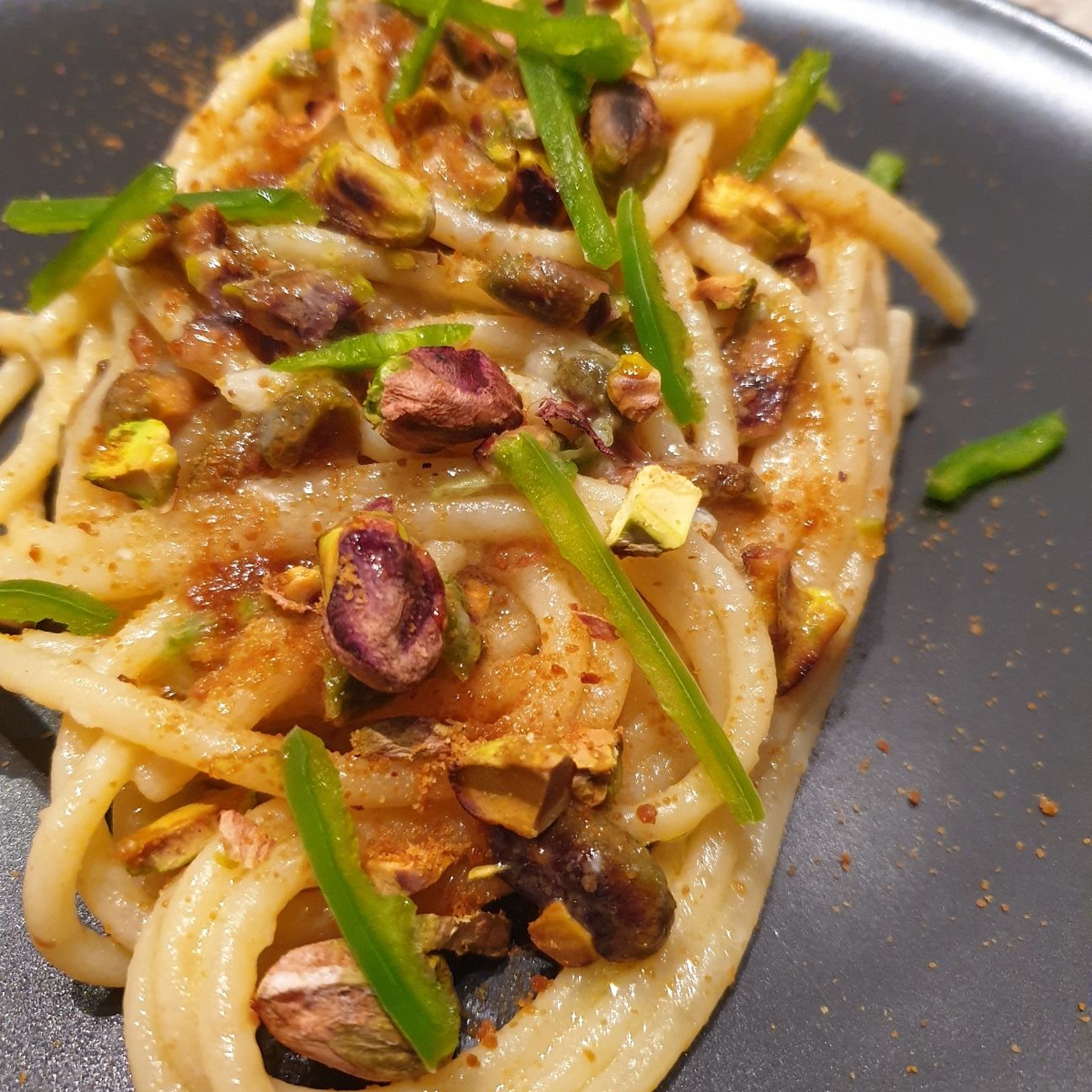 Spaghettoni XXL Garofalo in crema d'aglio, burro chiarificato e peperoncino fresco piccante con pistacchi tostati e bottarga di muggine.
