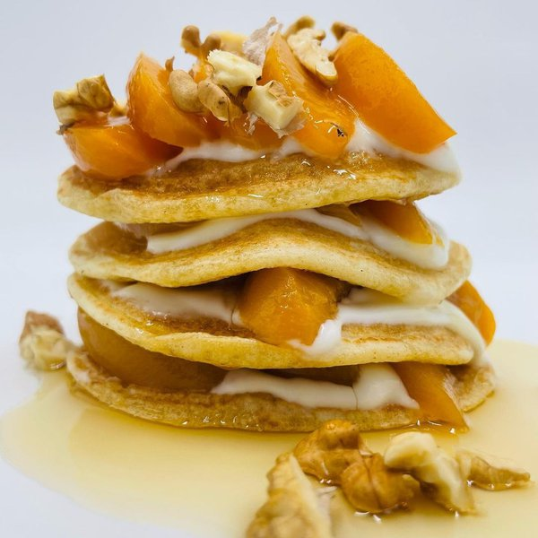 Pancake con pesche sciroppate e noci e sciroppo d'acero