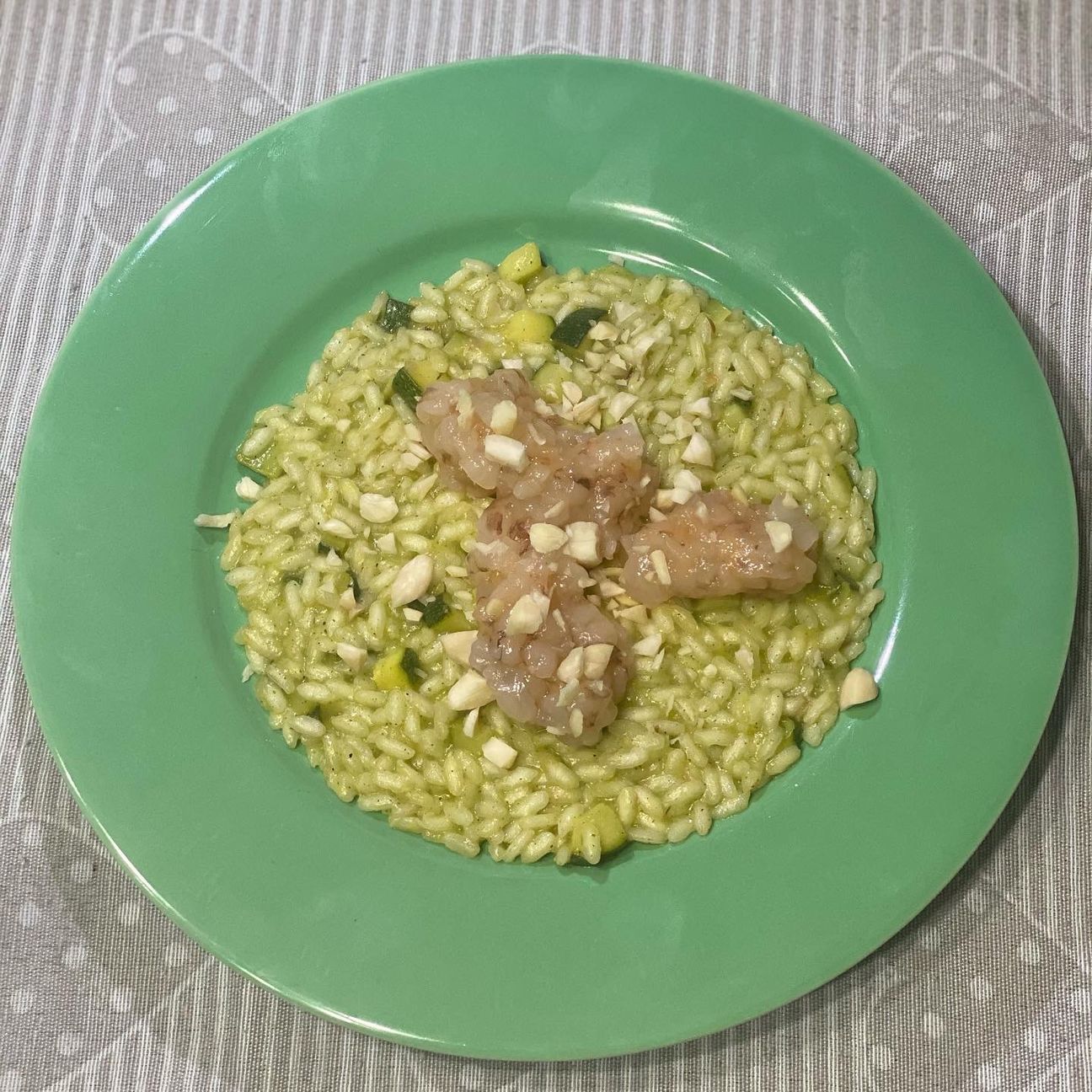 Risotto con tartare di gamberi al timo limone, cremoso di zucchine e nocciole tostate