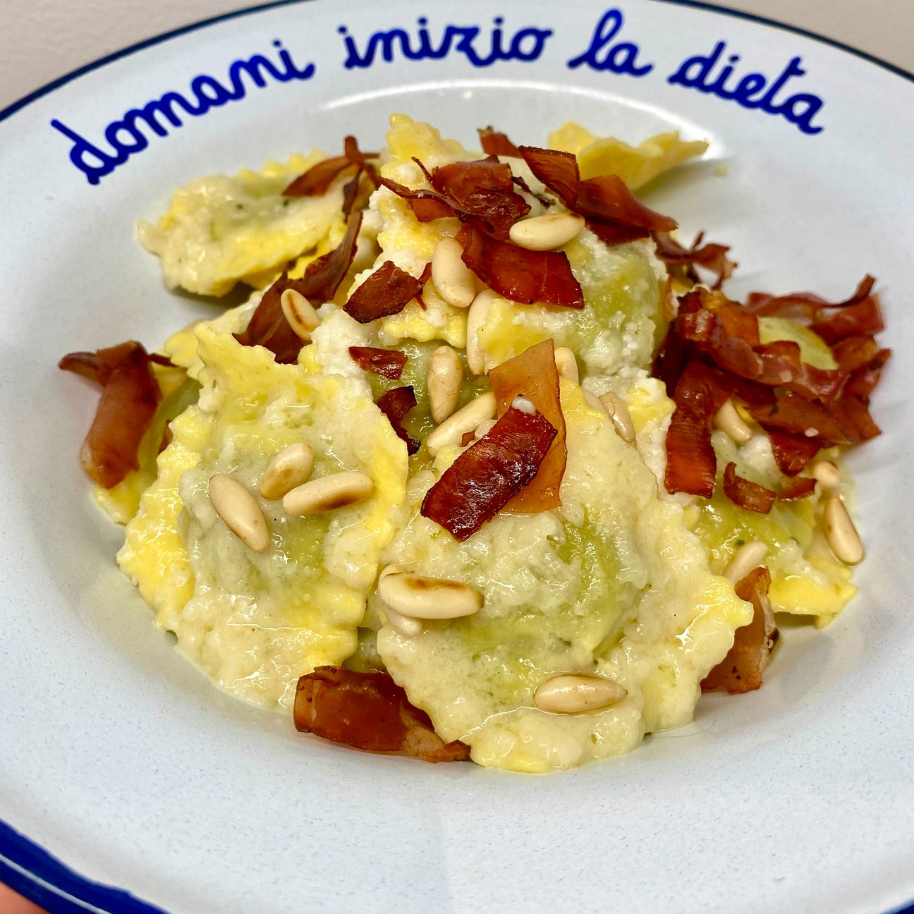 Ravioli ricotta e spinaci con crema di pecorino, speck e pinoli