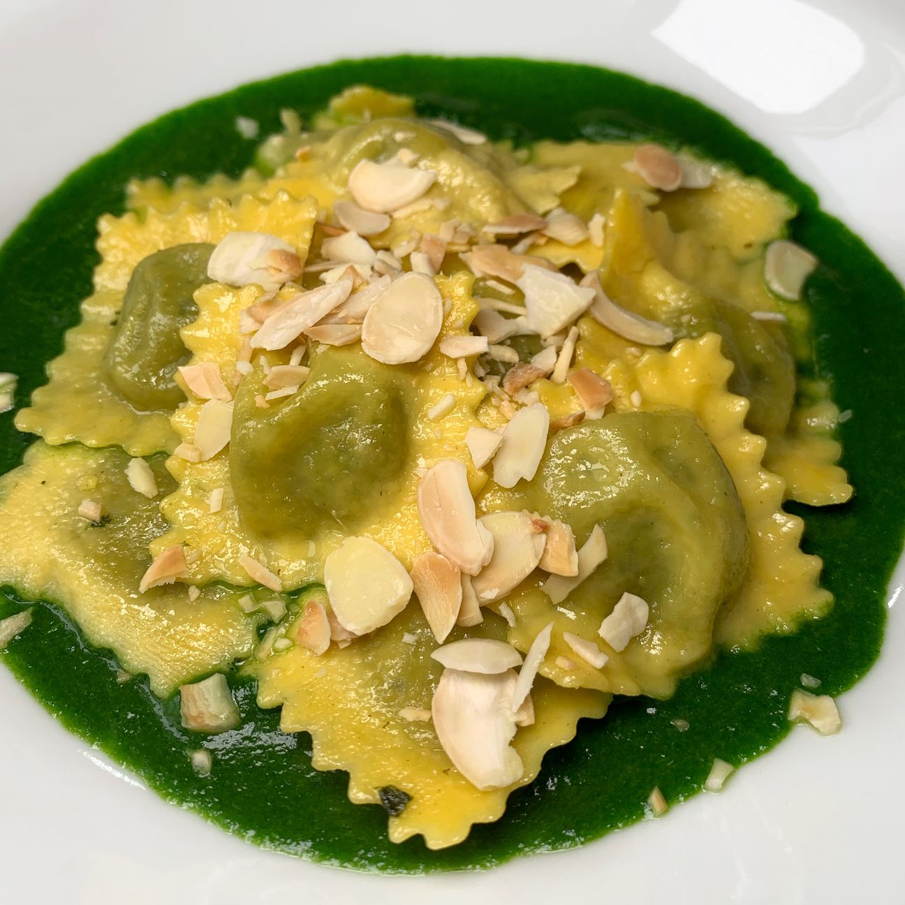 Ravioli ricotta e spinaci su crema di spinaci e mandorle tostate