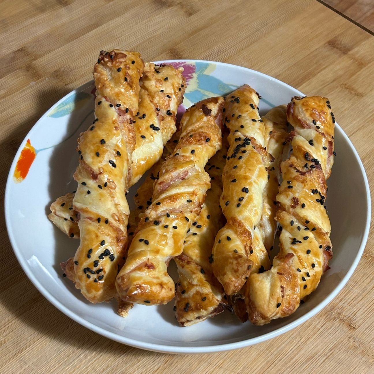 Grissini di pasta sfoglia ripieni di prosciutto e formaggi vari.