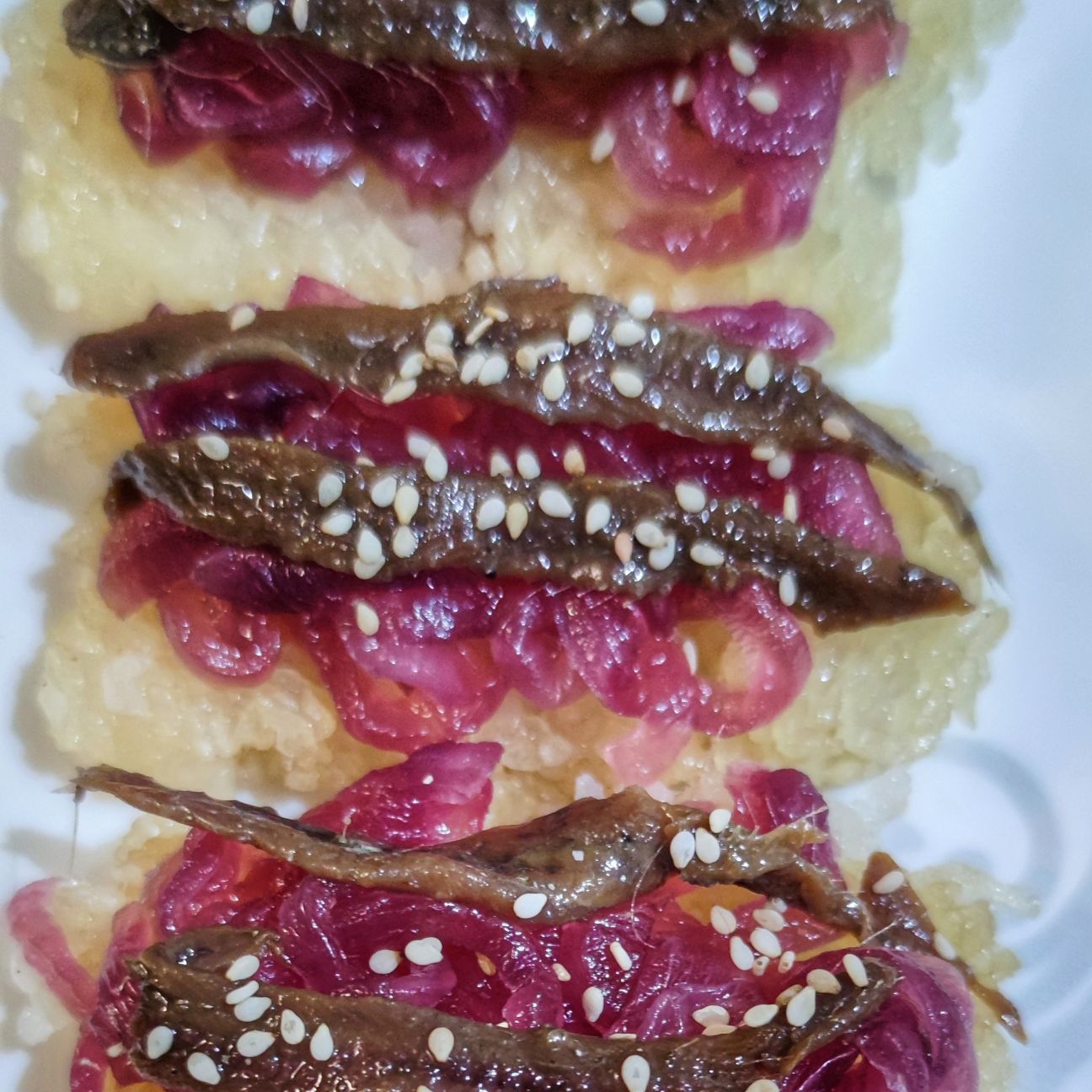 Crostini di riso, cipolla caramellata e acciuga