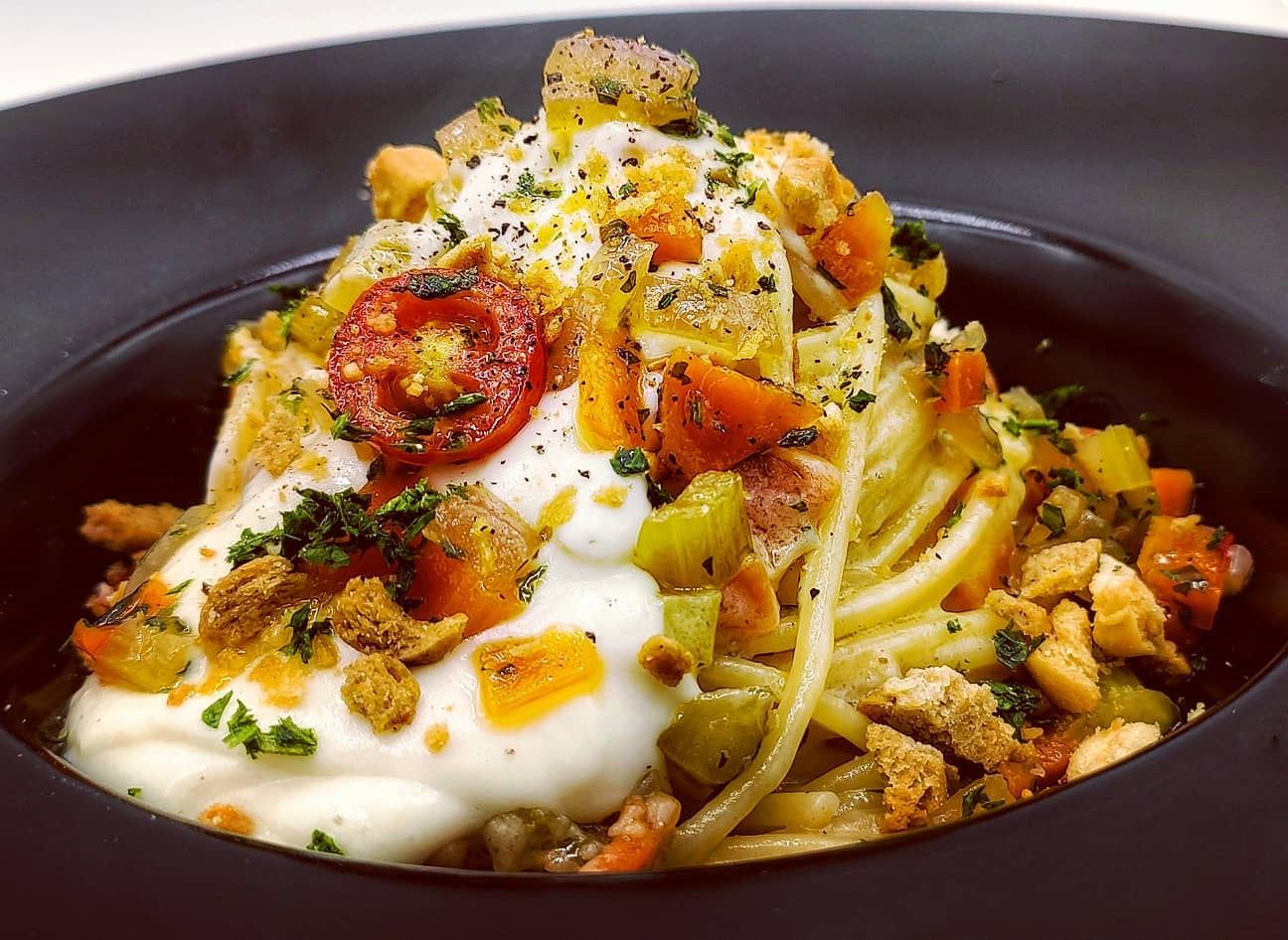 Spaghetti con verdure saltate, crema di parmigiano e tarallo