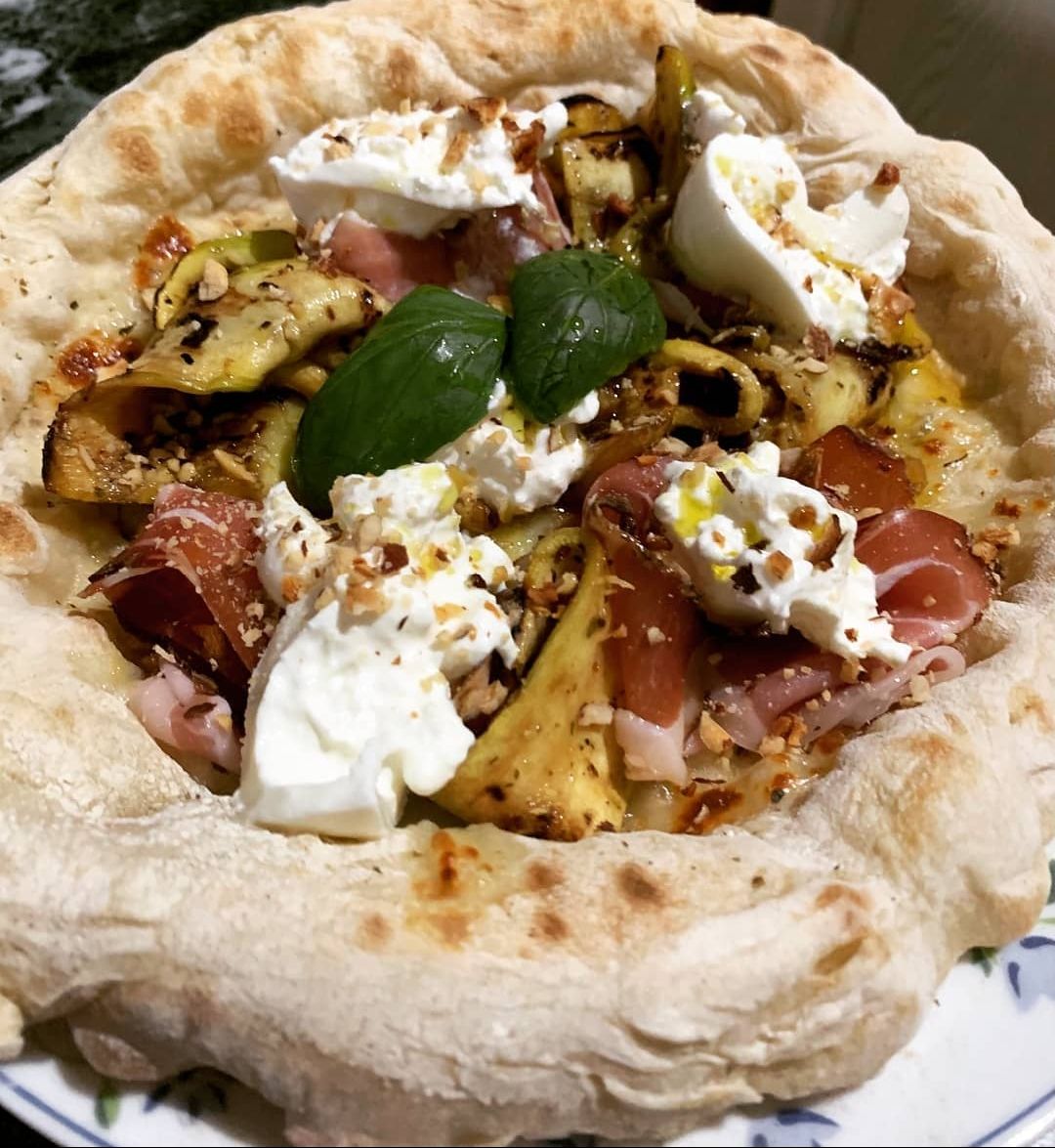 Pizza con prosciutto crudo, zucchine grigliate, stracciatella, granella di pinoli e nocciole , mozzarella