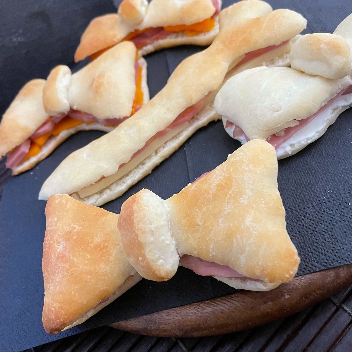 Papillon e cravatta di focaccia ripiena con formaggio cheddar o Philadelphia e mortadella