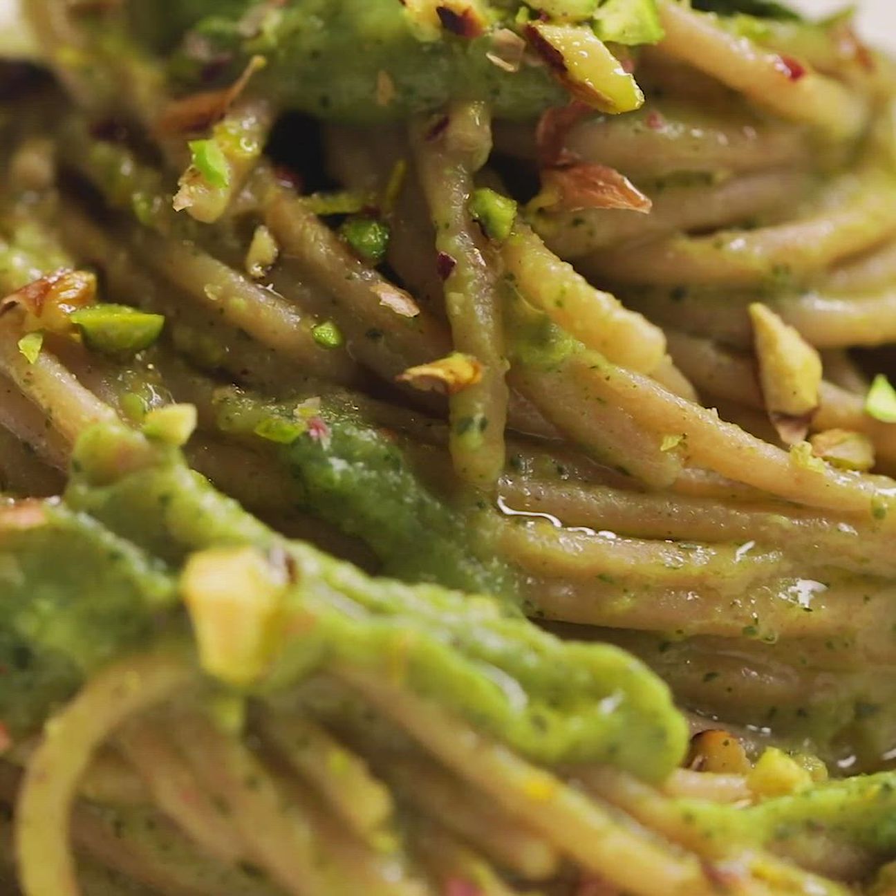 Spaghetti con crema di zucchine, fiori di zucca e pistacchi tostati con basilico
