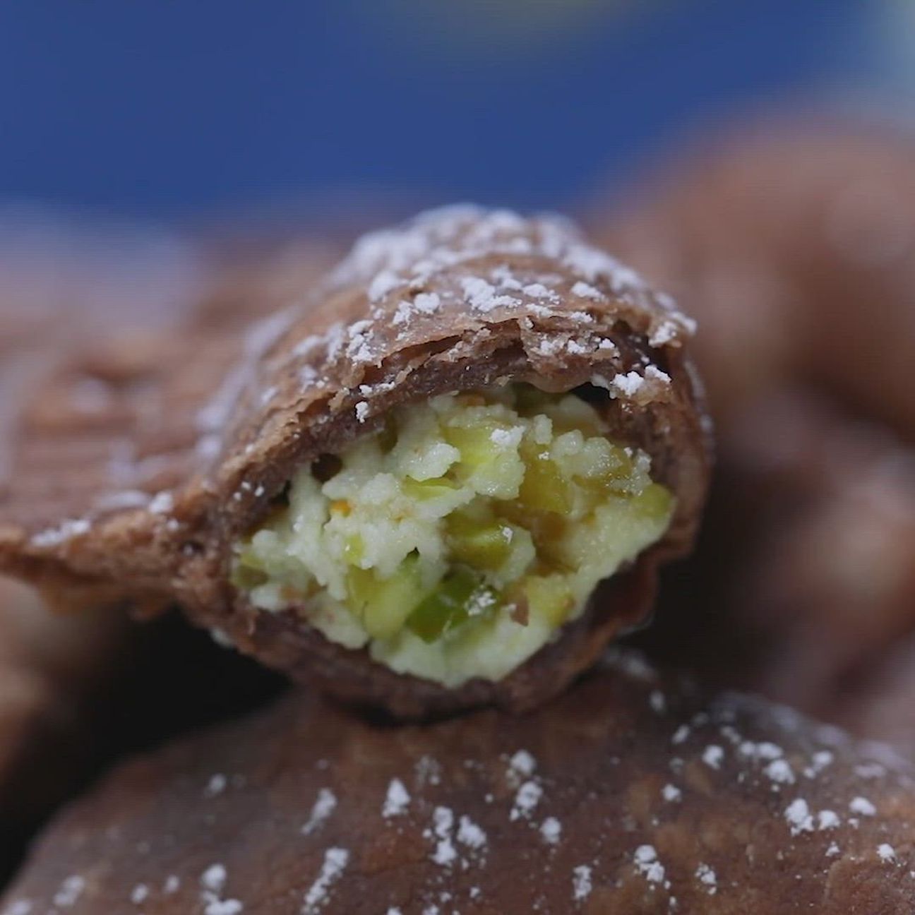 Ravioli fritti al cacao ripieni di ricotta e pistacchi