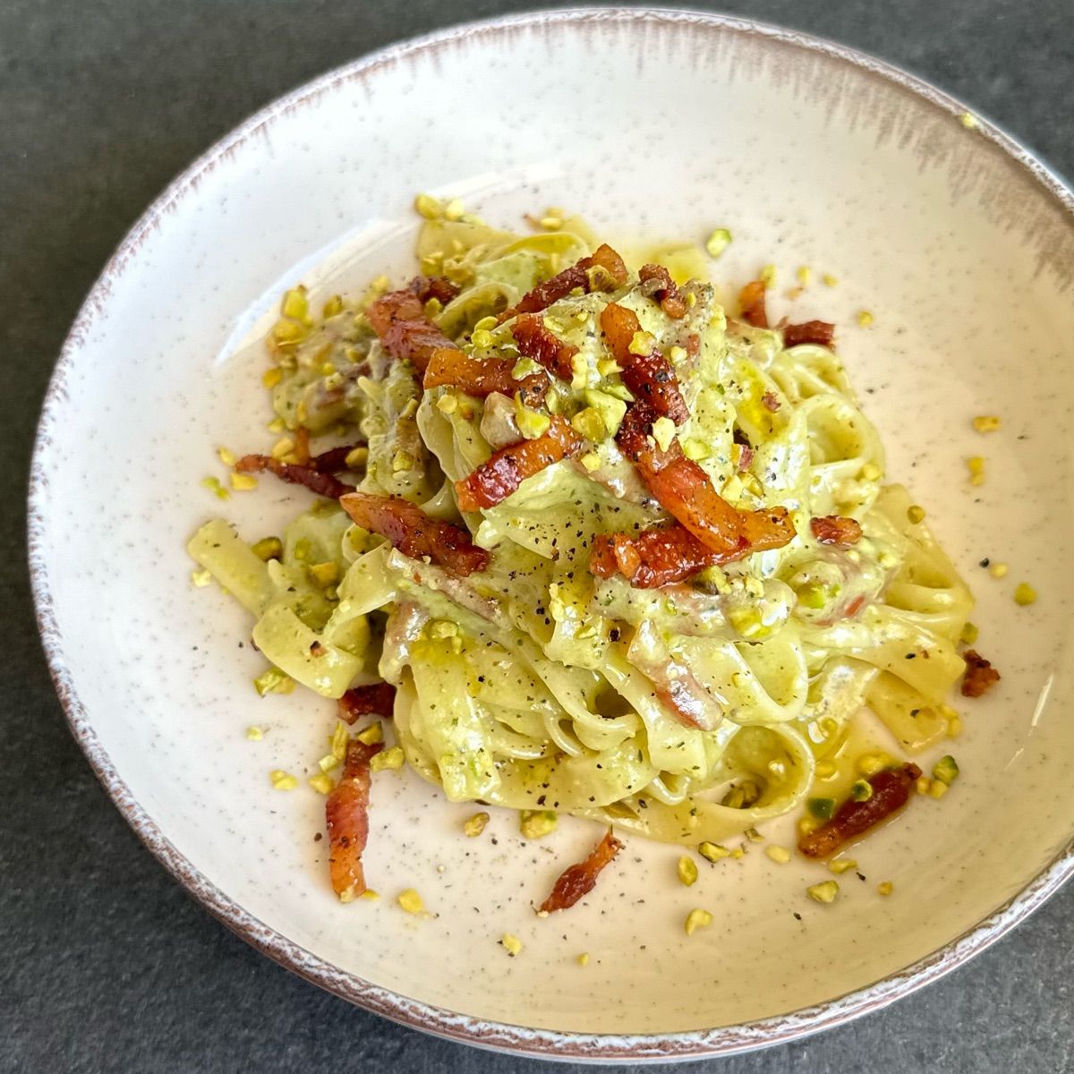 Tagliatelle Garofalo con fonduta di taleggio al pistacchio e pancetta affumicata