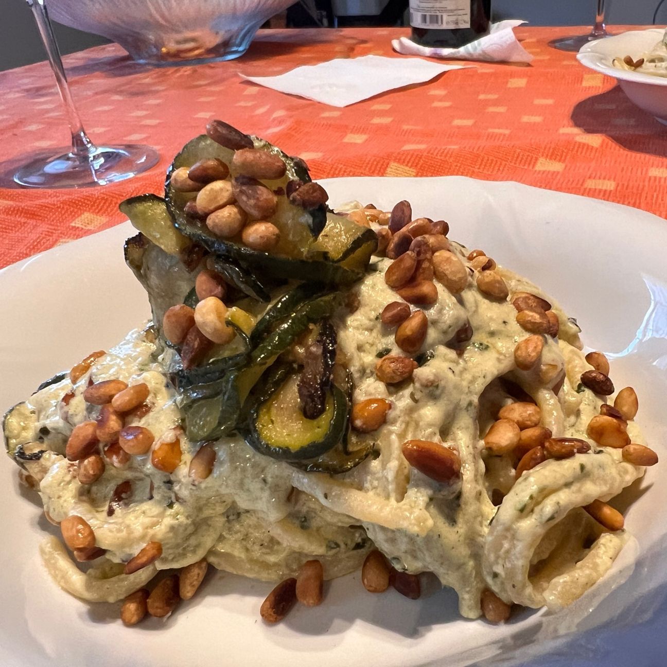 Spaghettoni con crema di burrata al basilico, zucchine fritte e pinoli tostati