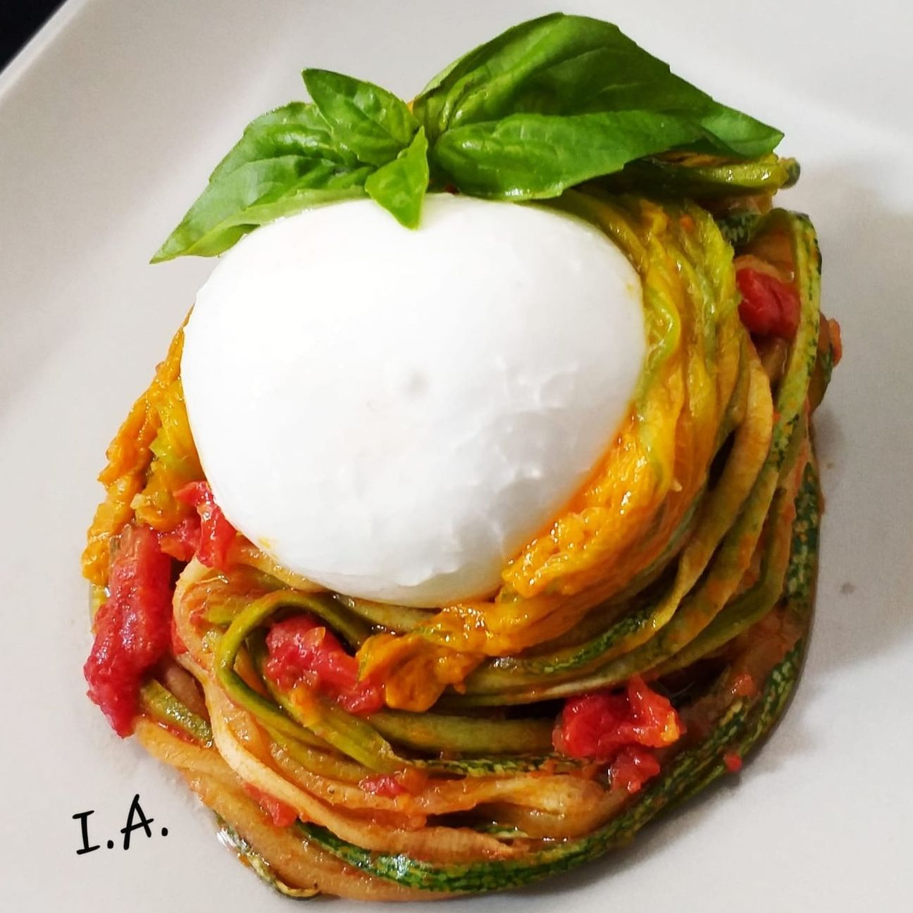 Spaghetti di zucchine con i loro fiori, pomodoro e basilico con bocconcino di mozzarella di bufala.