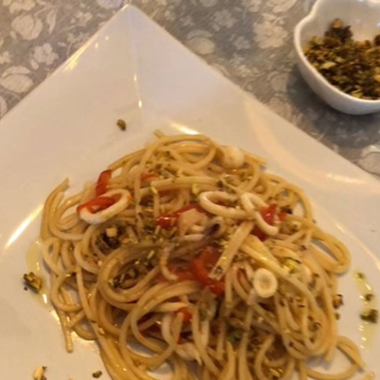 Spaghetti calamari, peperoni e pistacchi