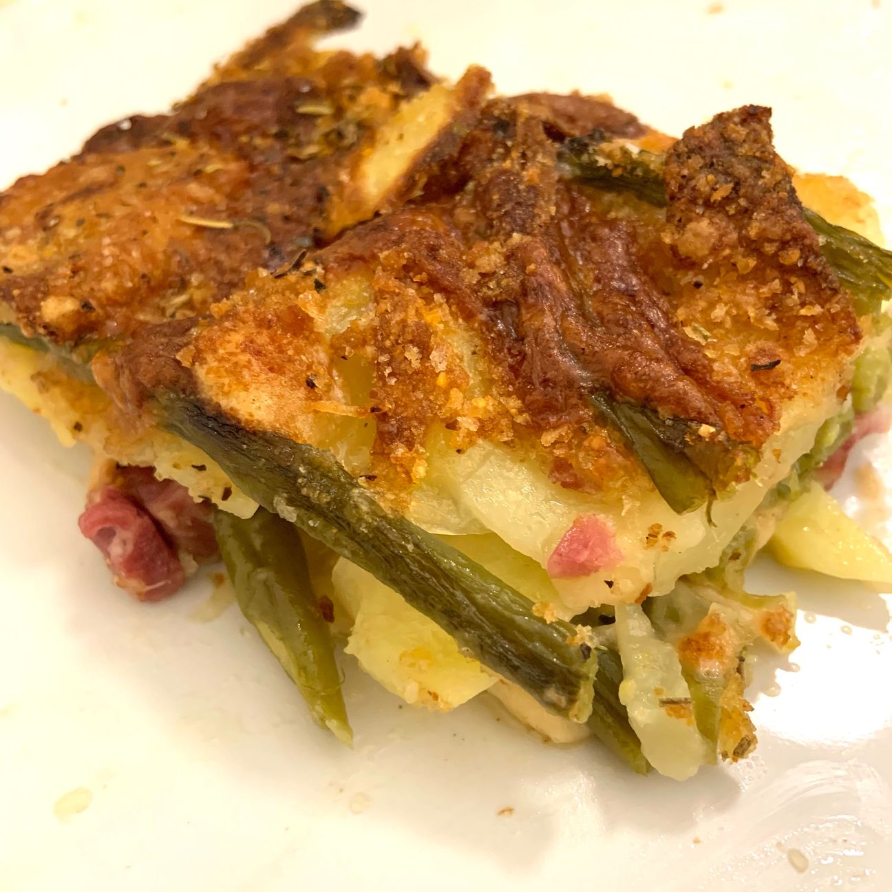 Parmigiana di patate, fagiolini, provola e cotto