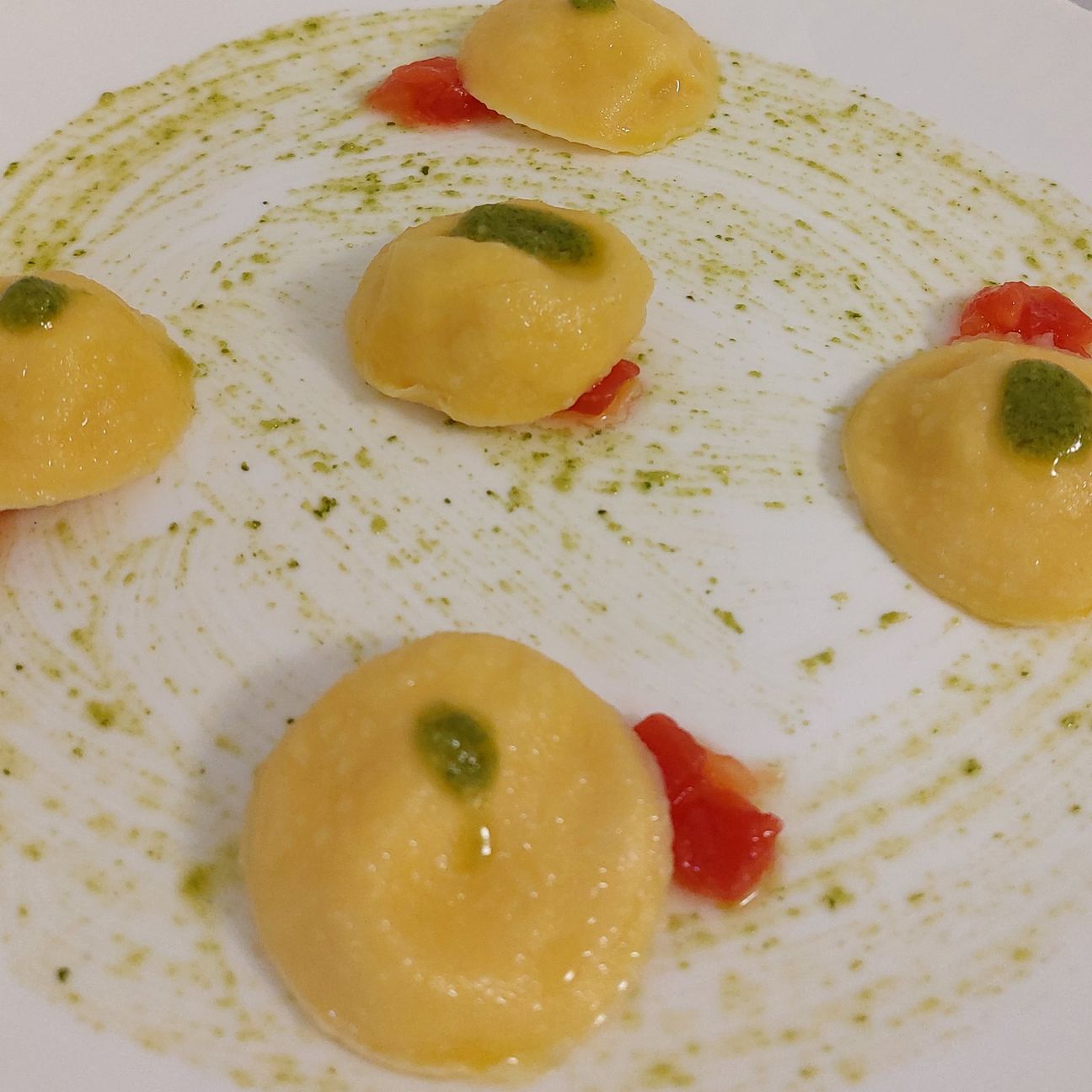 Bottoni di pasta all'uovo ripieni di patate e baccalà, pesto e pomodorini
