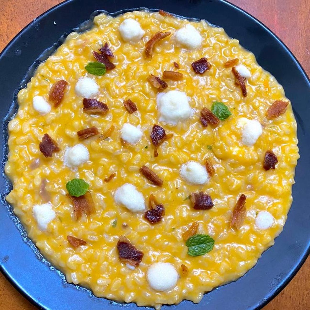 Risotto alla zucca con petali di guanciale croccante e spuma di pecorino