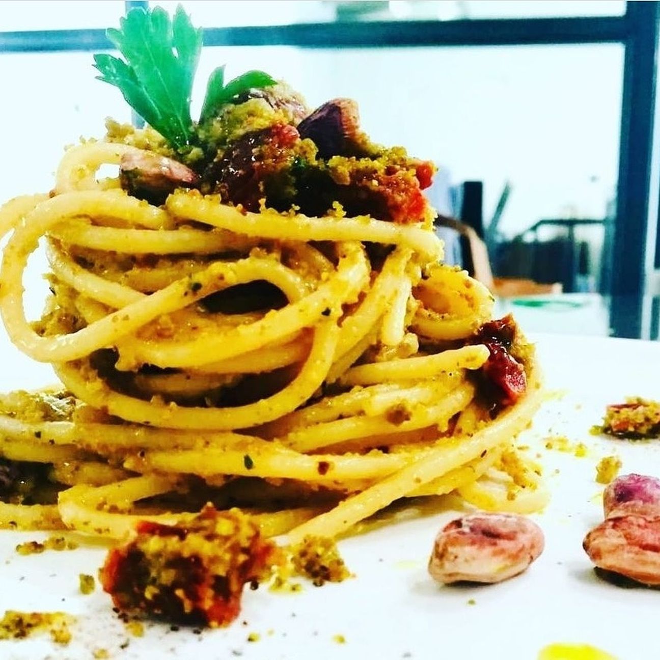 Spaghetti con pomodori secchi e pane croccante al pistacchio