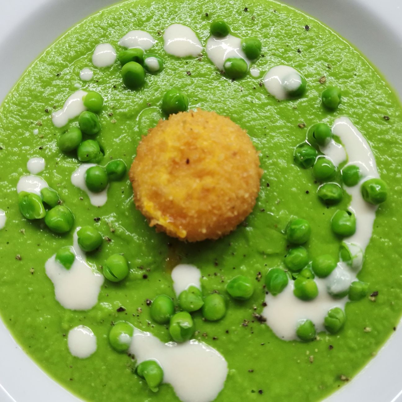 Vellutata di piselli con tuorlo fritto e fonduta di parmigiano