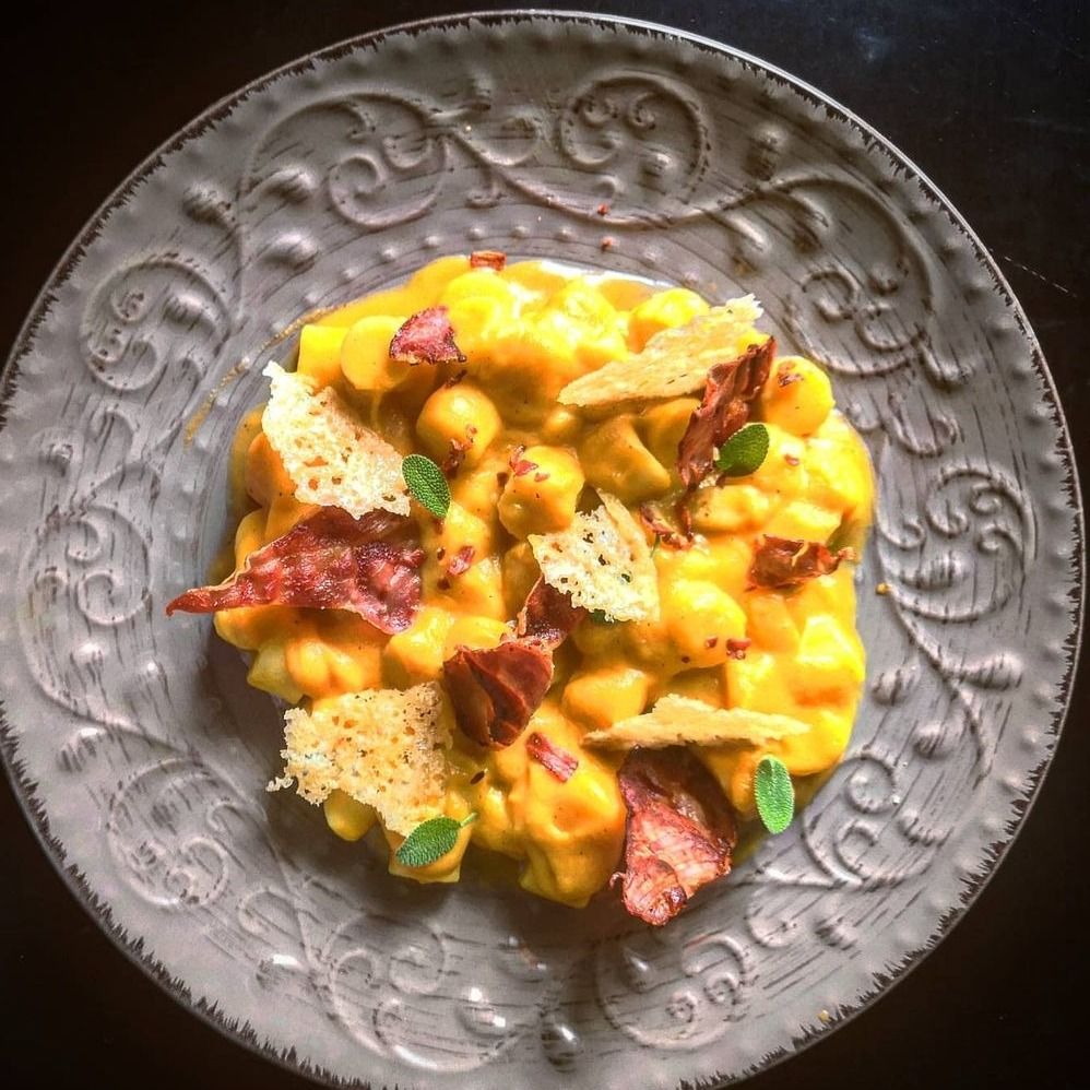 Gnocchi zucca e speck con chips di parmigiano.