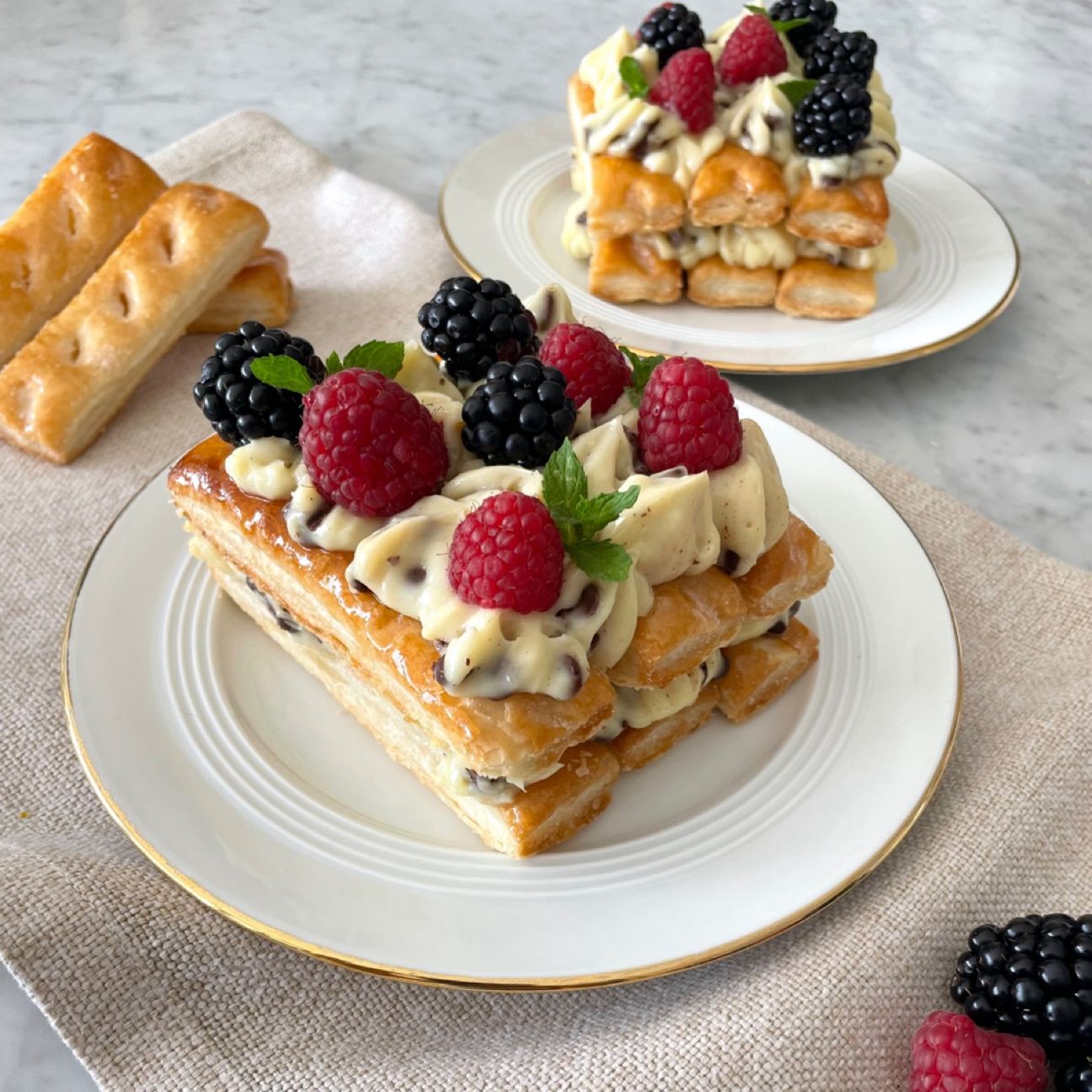 Millefoglie con crema pasticciera, gocce di cioccolato e frutti di bosco