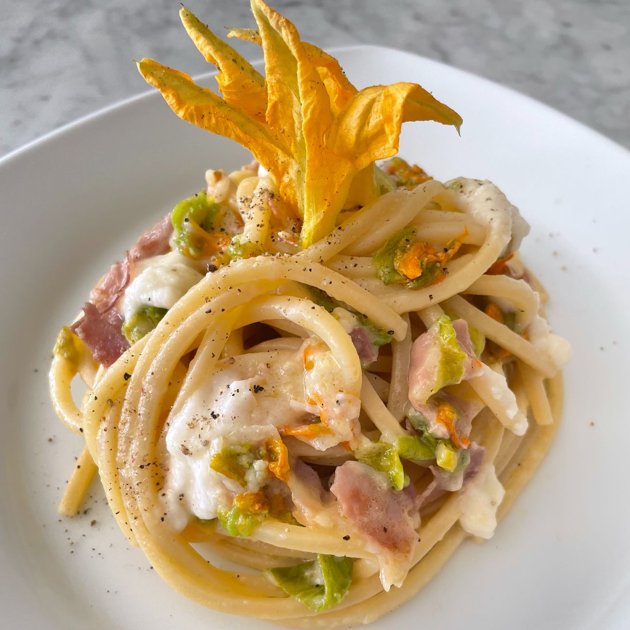 Chitarra con fiori di zucca, crema di parmigiano e crudo croccante 😋
