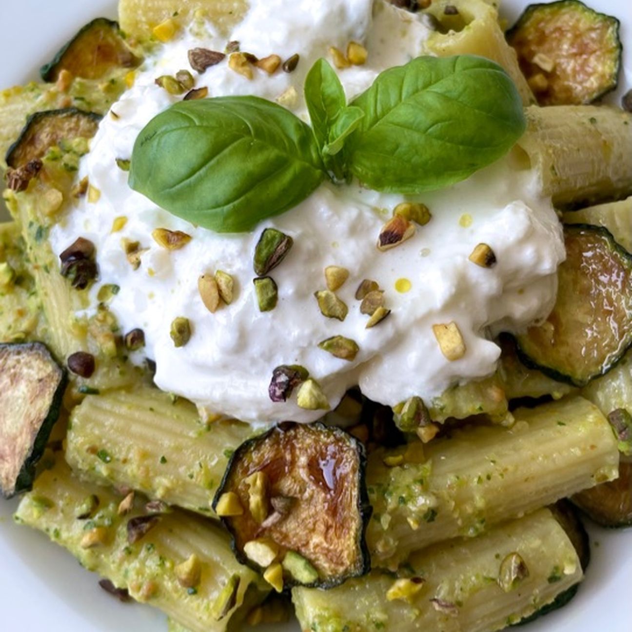 Rigatoni con crema di zucchine e pistacchi, stracciatella e chips di zucchine