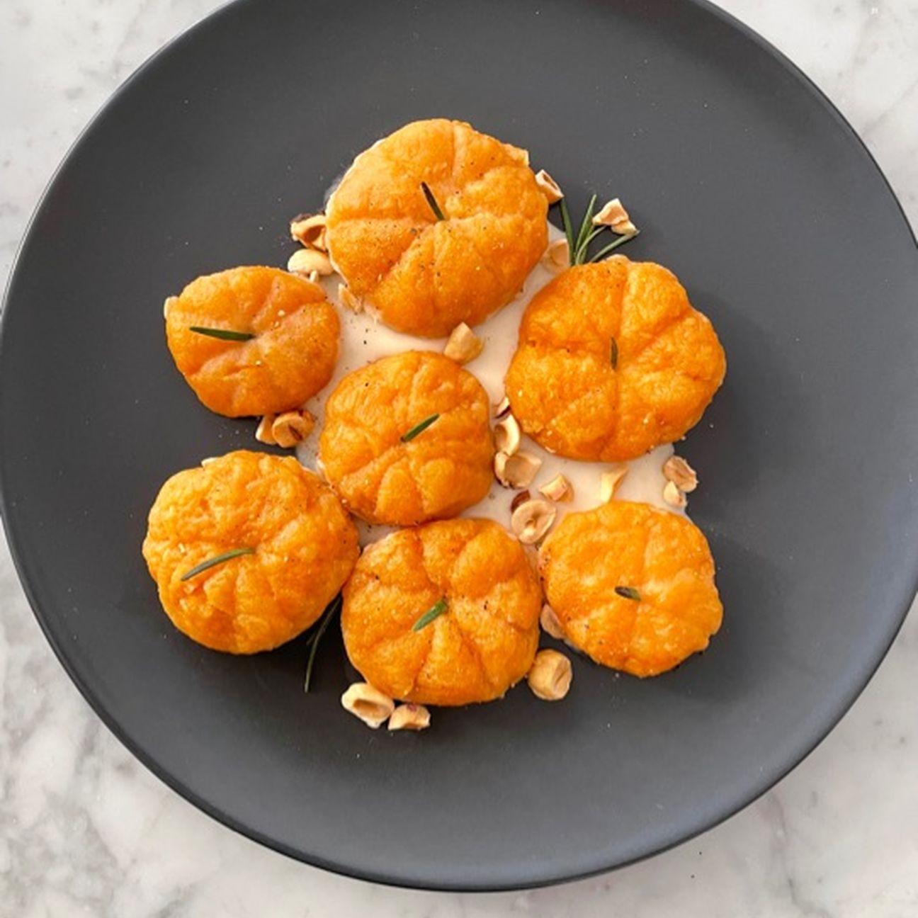 Gnocchi di zucca con crema al parmigiano e nocciole