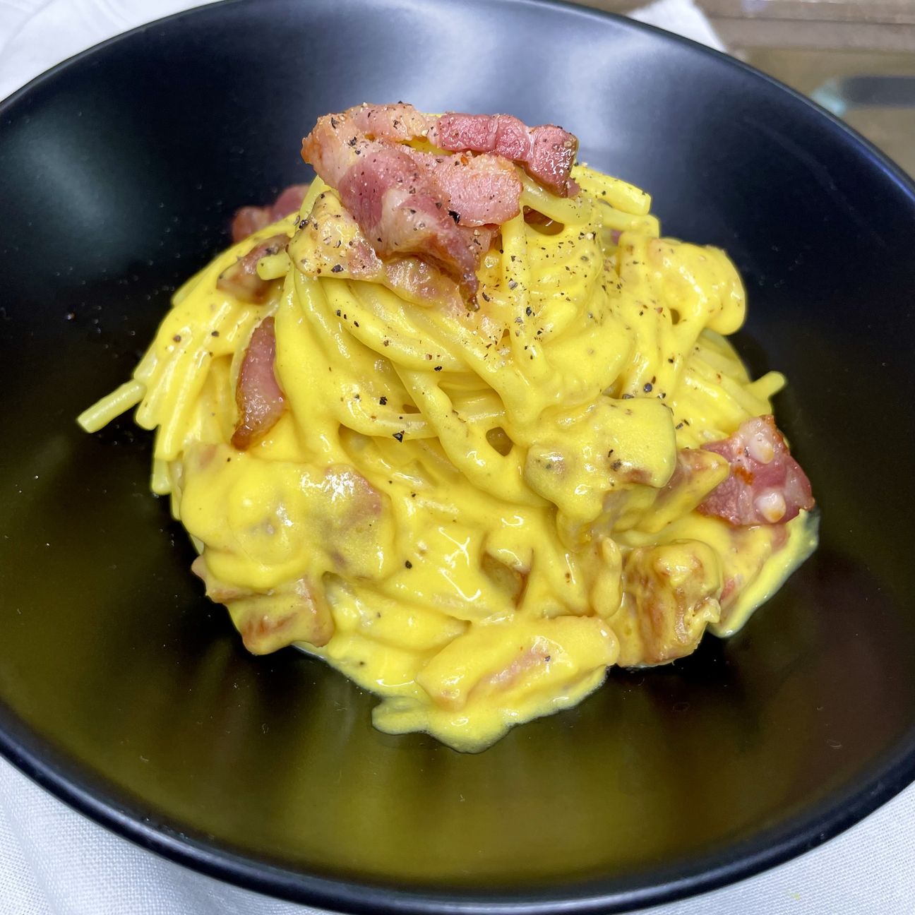 Spaghetti con crema di parmigiano, zafferano e pancetta affumicata