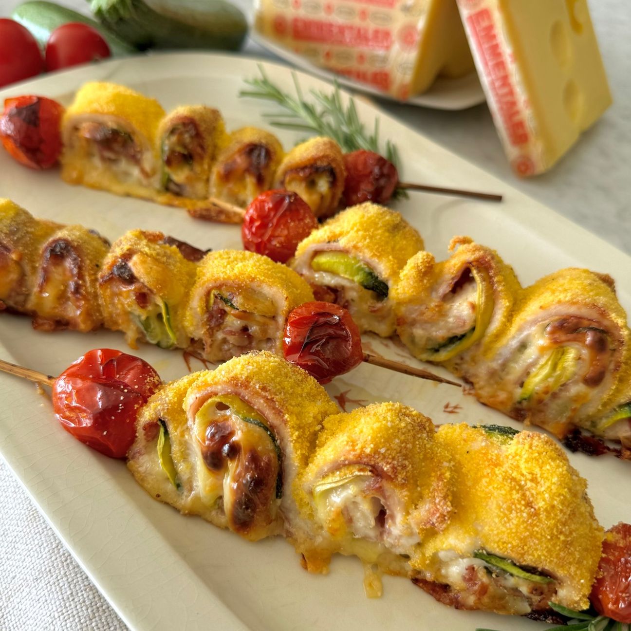 Spiedini di pollo con speck, zucchine, Emmentaler DOP e pomodori