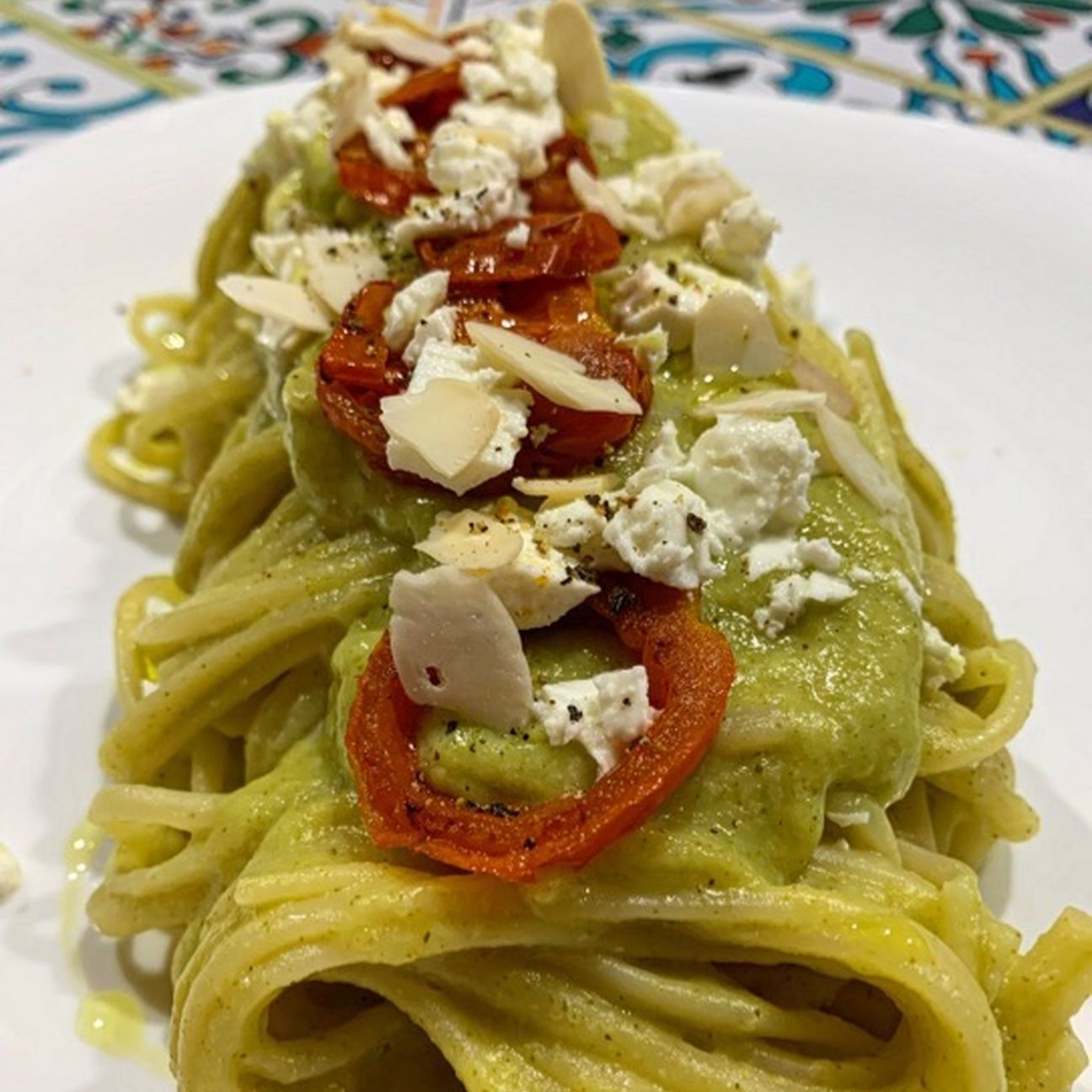 Spaghetti al pesto di broccoli e feta, ciliegino semidry e petali di mandorle