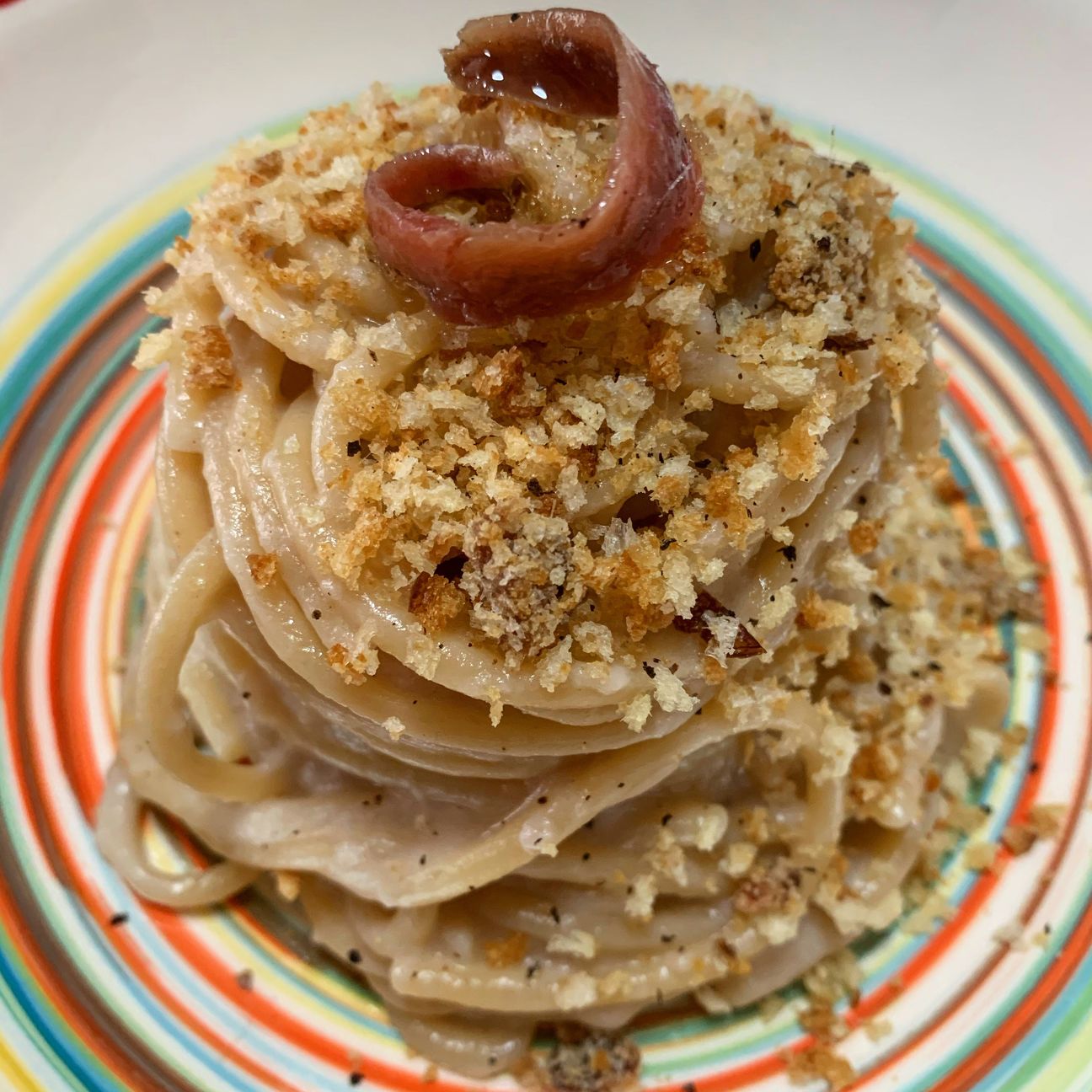 Spaghetti con crema di cipolle, acciughe e croccante di mollica tostata