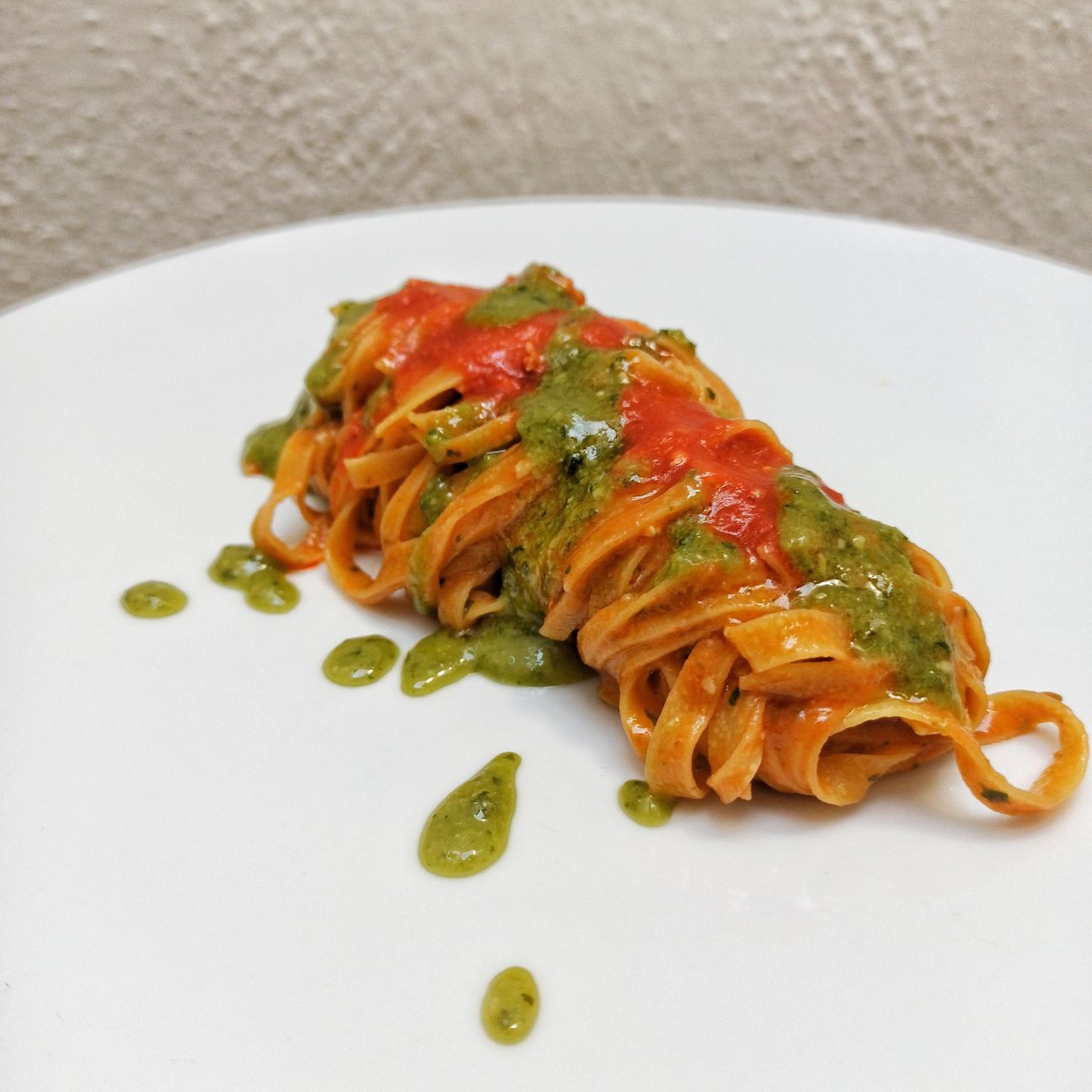 Tagliolini all'uovo, con guazzetto di datterino rosso, mantecati con scamorza affumicata, pesto di basilico
