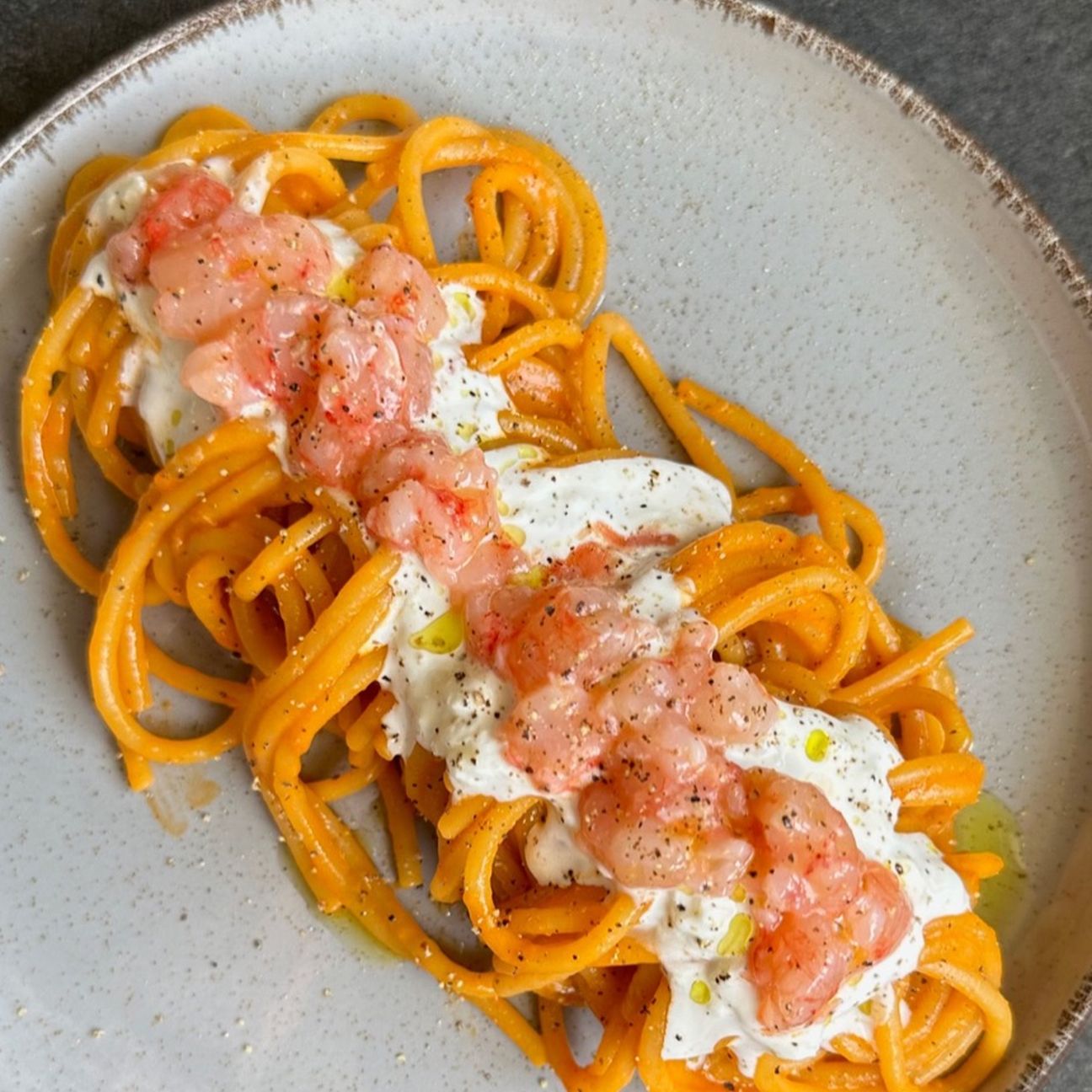 Spaghetti Pasta Garofalo con crema di pomodorini confit, stracciatella e tartare di gamberi