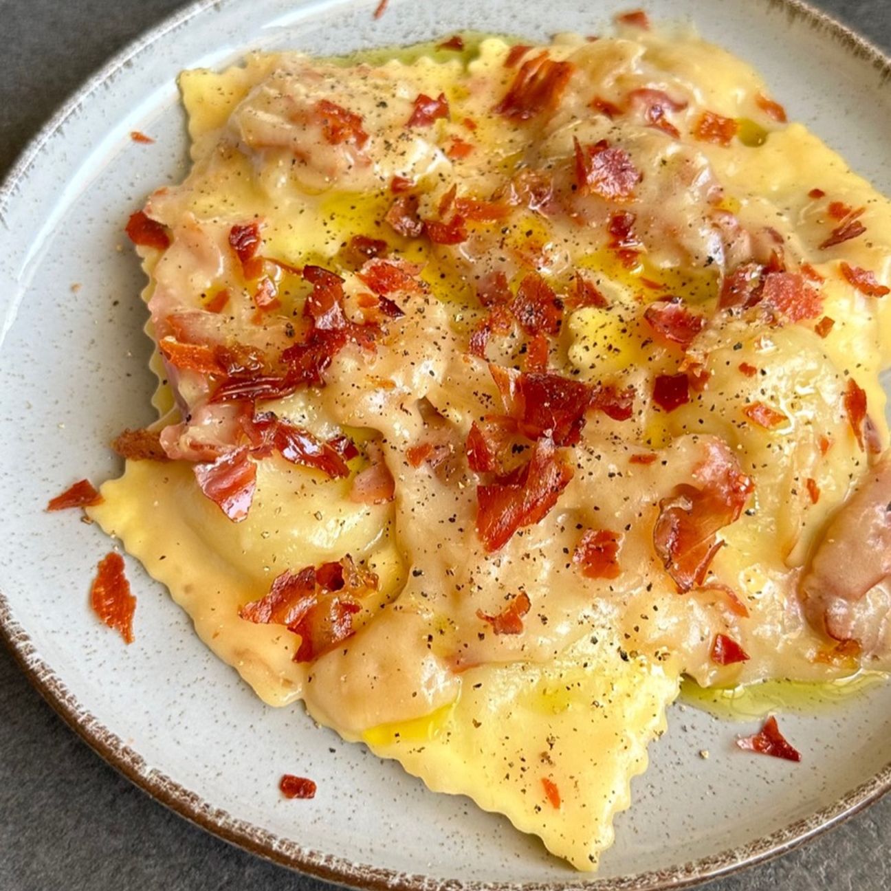 Ravioli scamorza e radicchio Fini Modena con salsa alla birra bionda e speck croccante