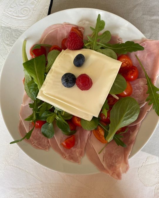 Insalata sul letto di prosciutto pomodori e frutta