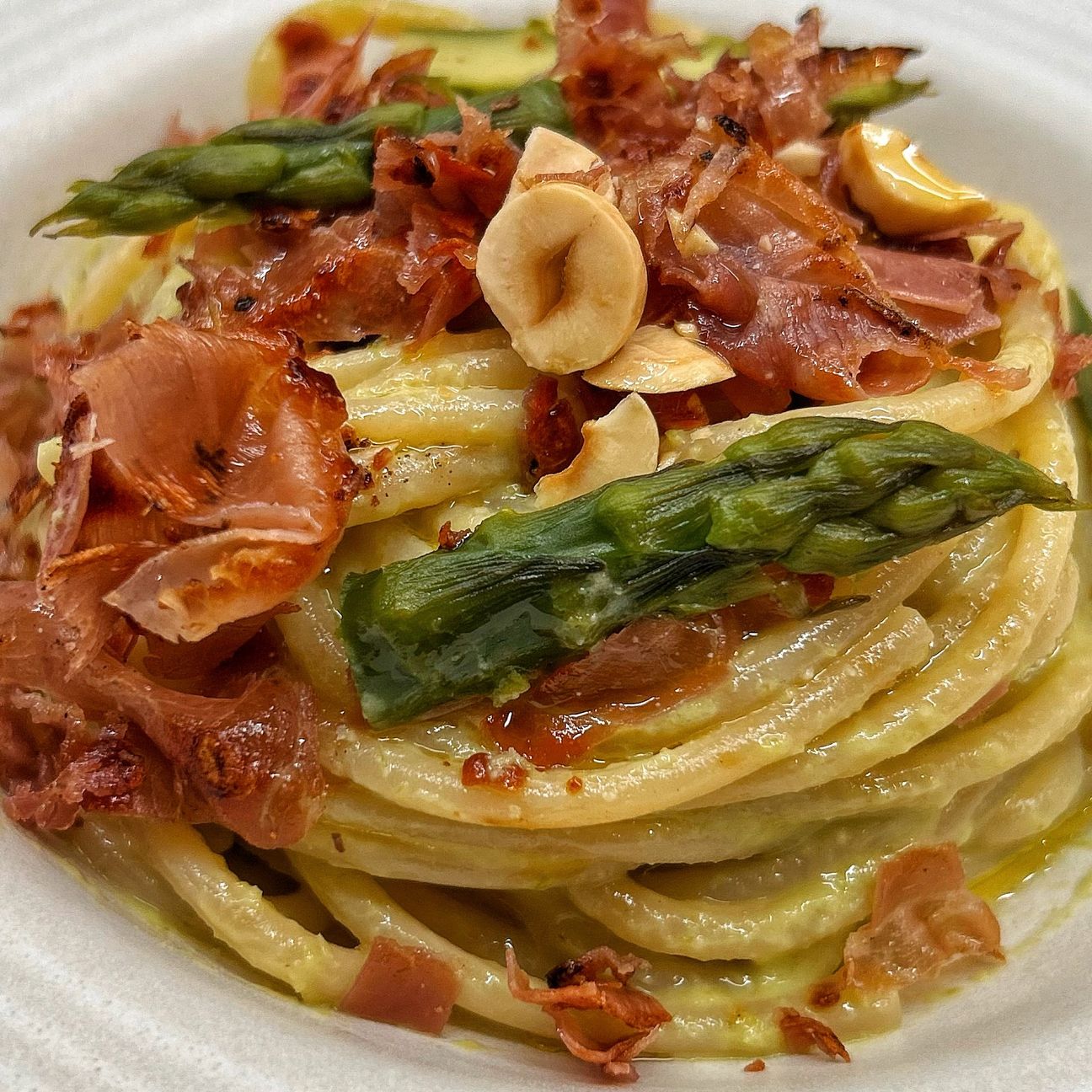 Spaghettone con crema di asparagi, stracchino, nocciole e crudo croccante 😋