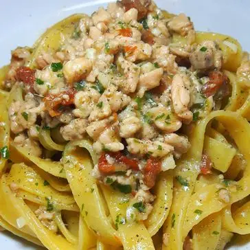 Ricetta Tagliatelle con ragù di salmone e pomodorini secchi profumato all'aglio.
