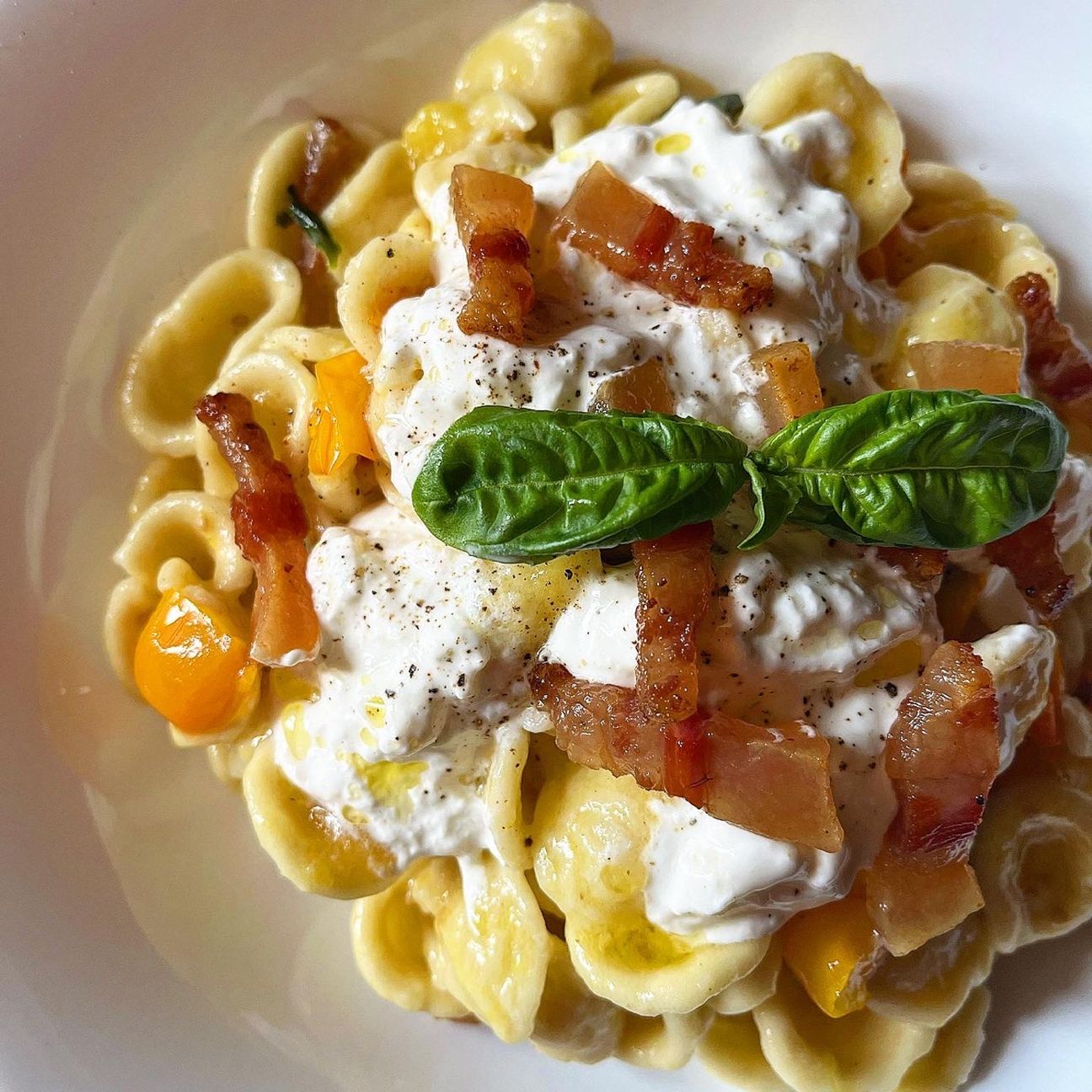 Orecchiette con datterini gialli, pancetta paesana, stracciatella di burrata e basilico