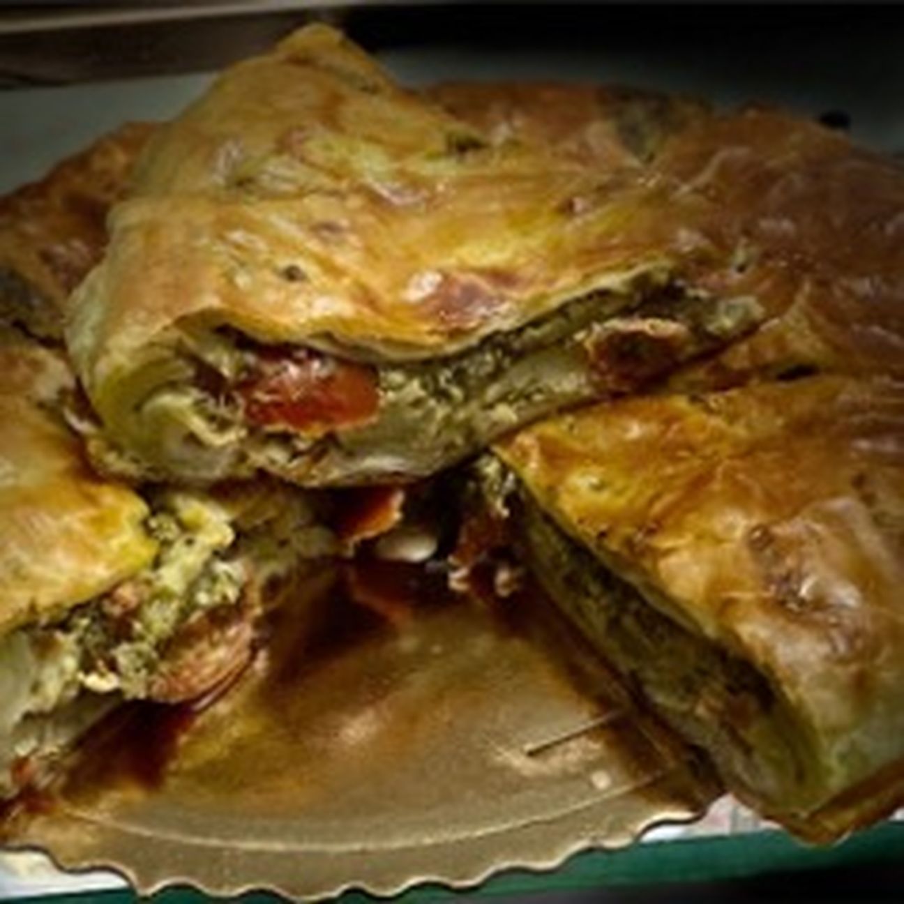 Torta salata con pesto di pistacchi, treccione di bufala e datterini