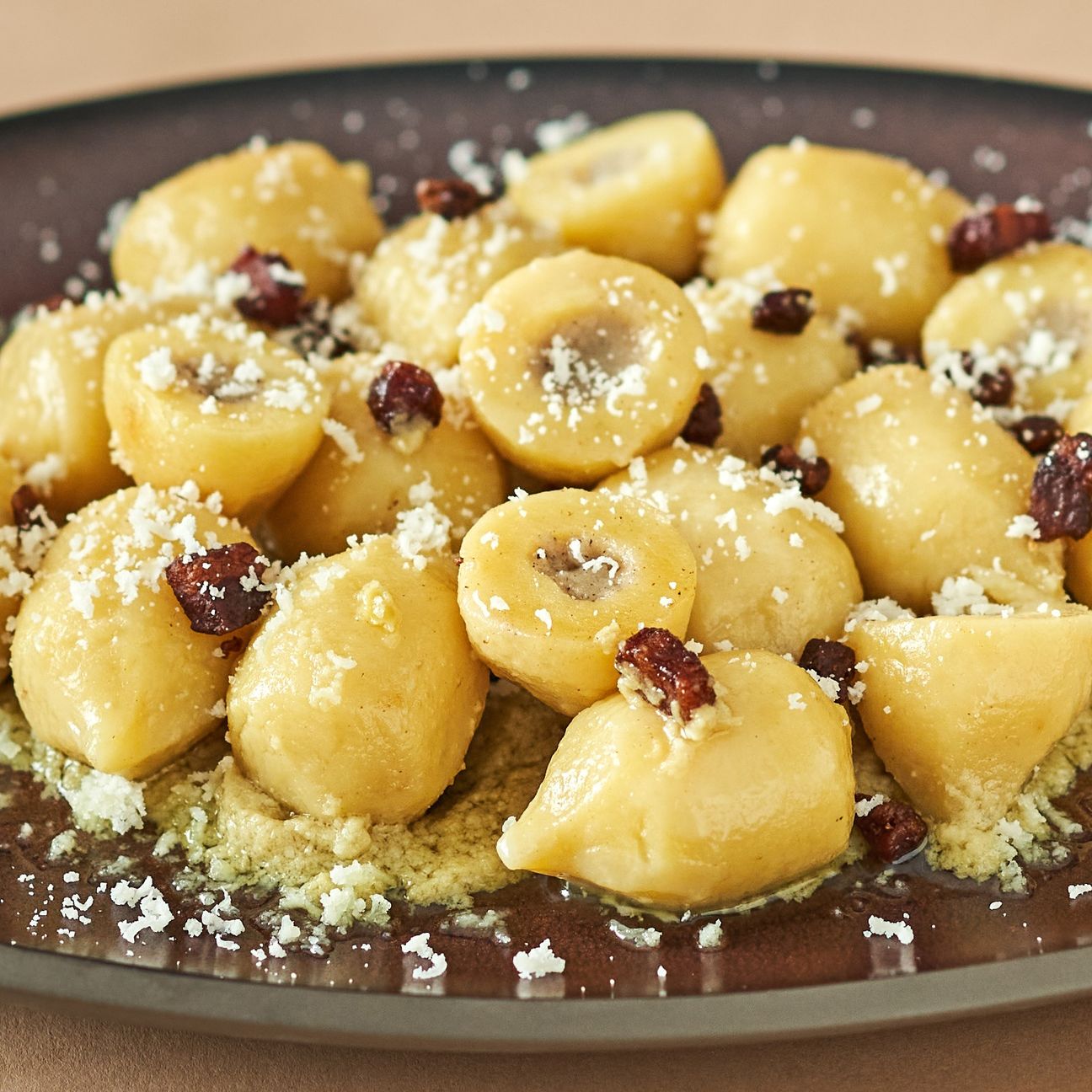 Gnocchi ripieni di cacio e pepe con crema di carciofi e guanciale croccante