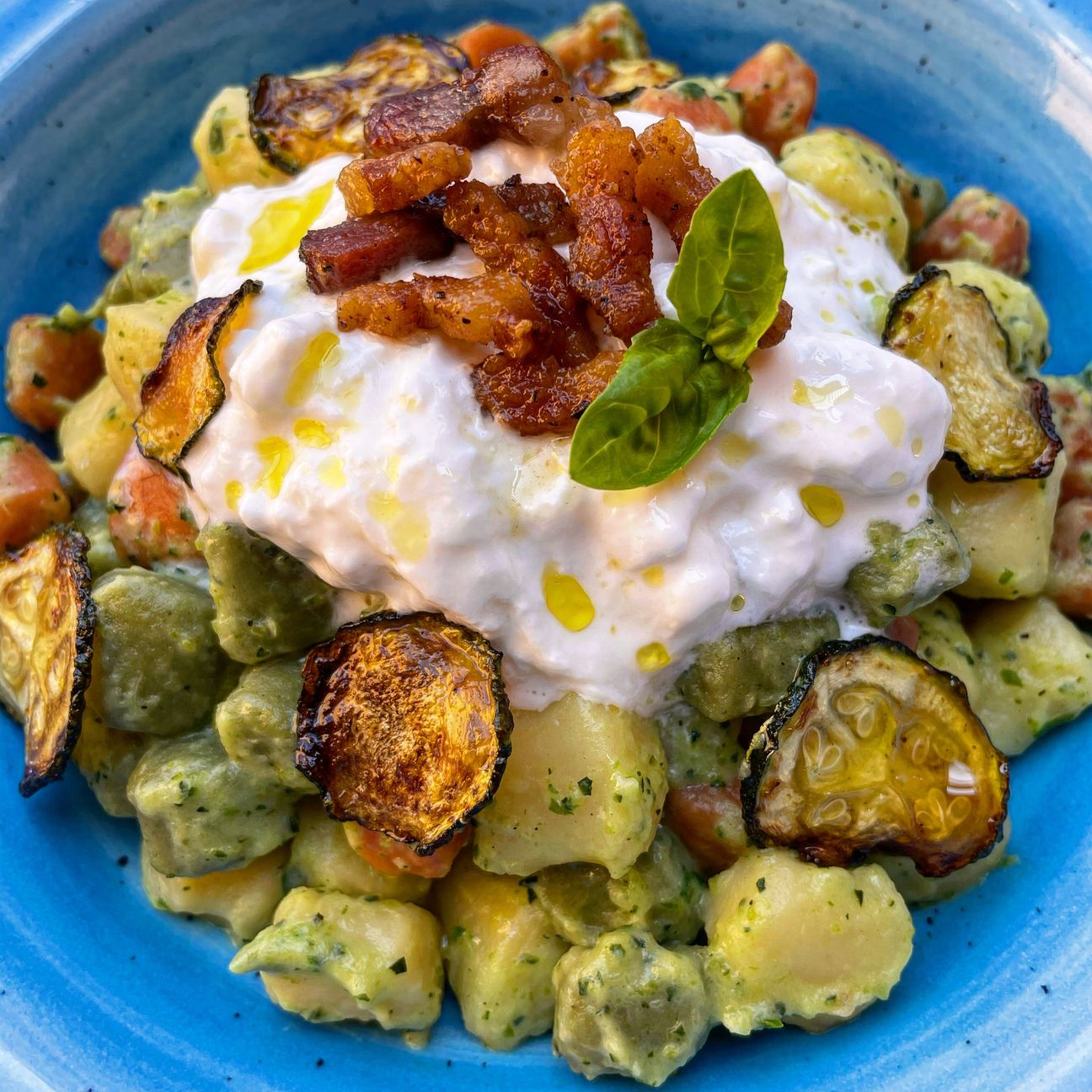 Chicche di patate con crema di zucchine, chips di zucchine, stracciatella e guanciale