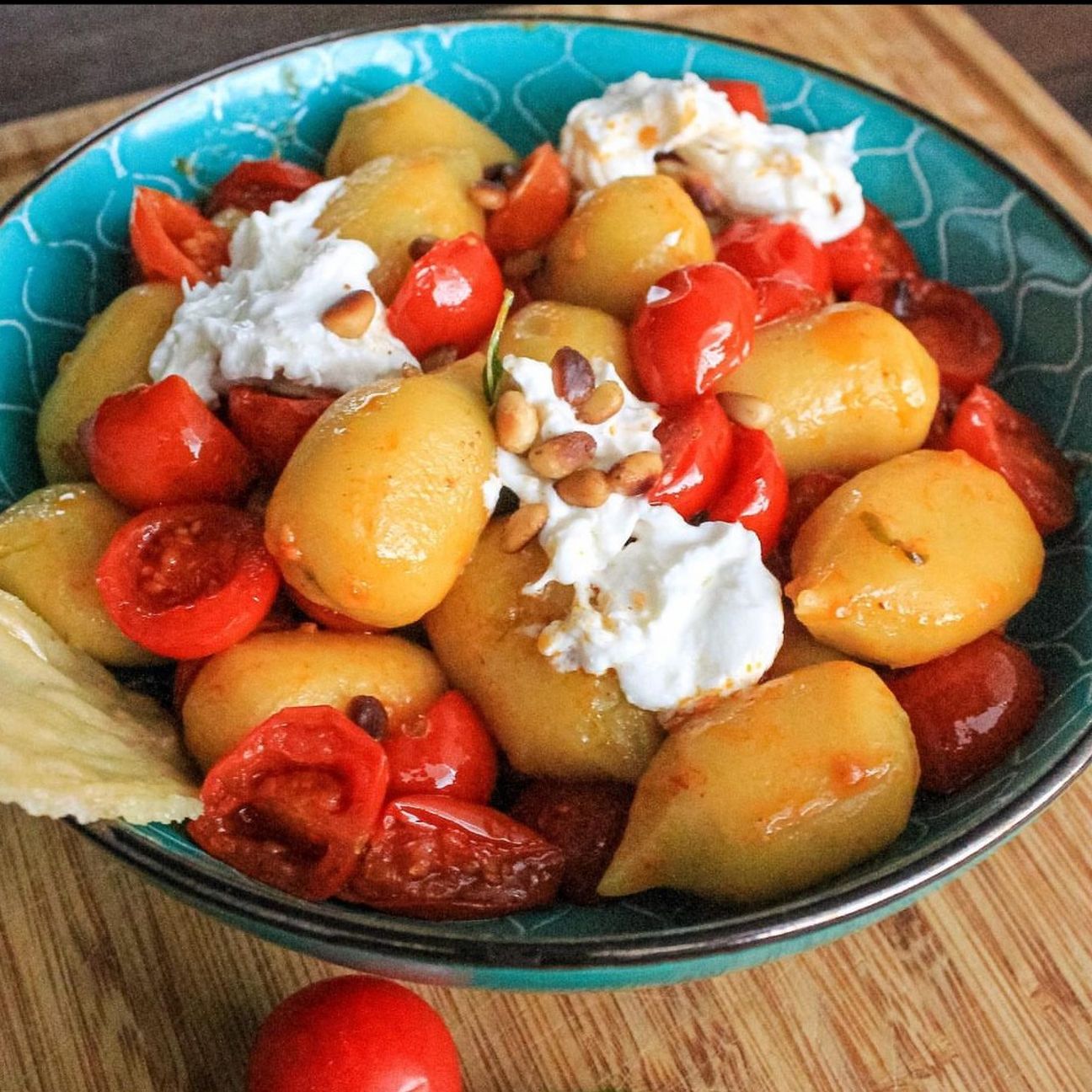 Gnocchi ripieni al pesto genovese con stracciatella, pomodorini confit e pinoli