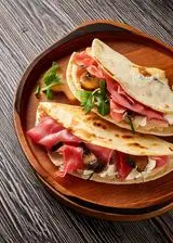 Ricetta Piadina con prosciutto crudo, crescenza e funghi grigliati